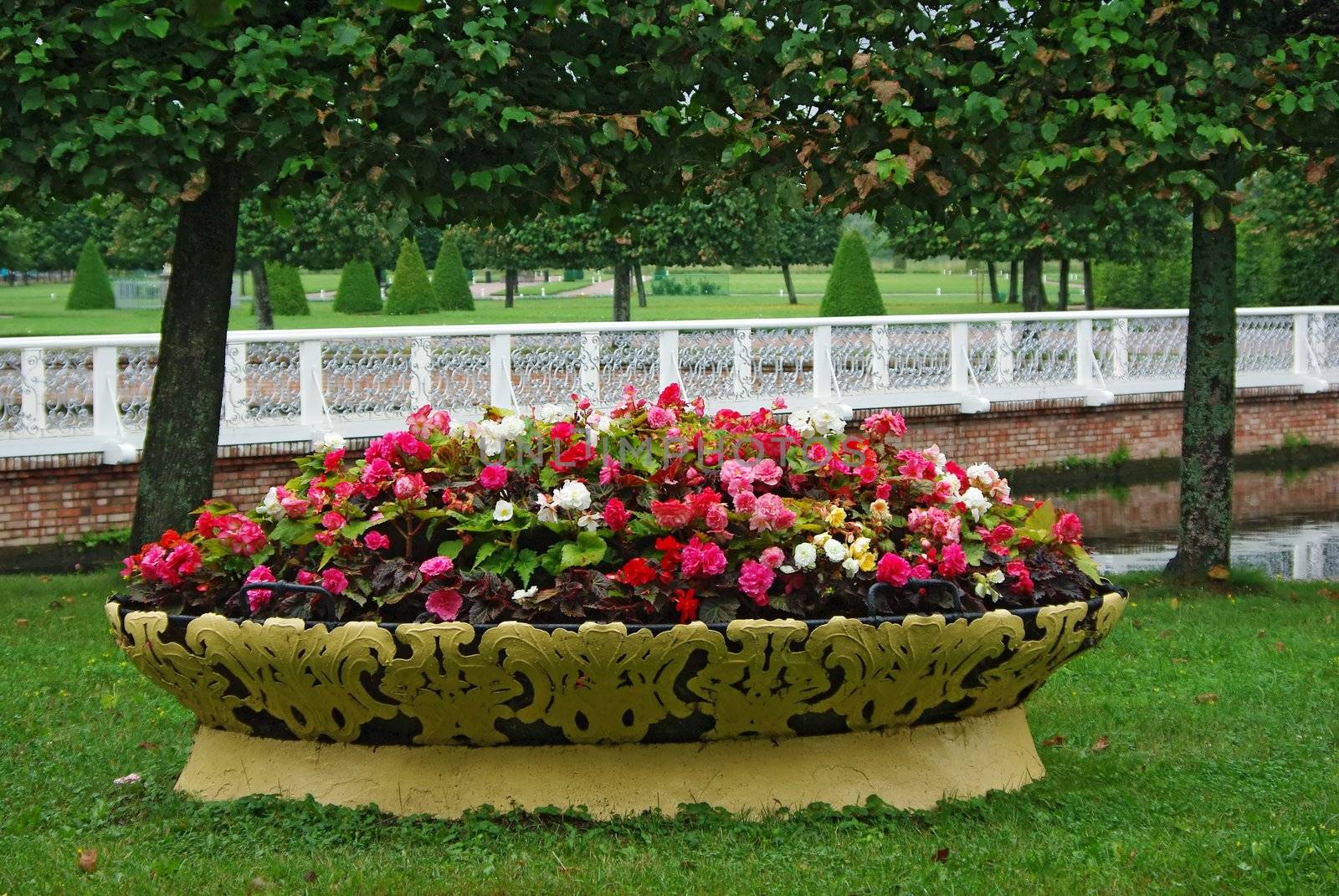 Flowerbed full of all colors flowers in front of white fence