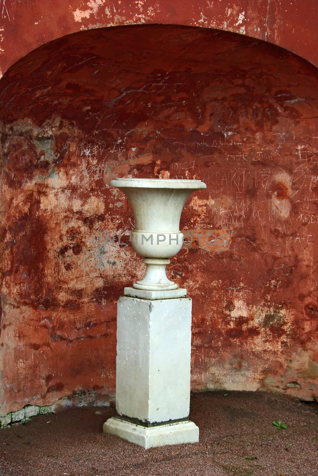 Marble vase on backdrop of defaced ancient wall by Vitamin