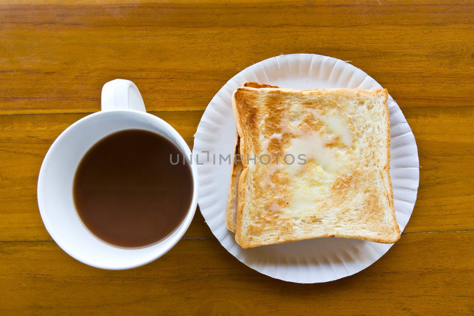 Coffee cup and Pour the milk toast on the wooden table