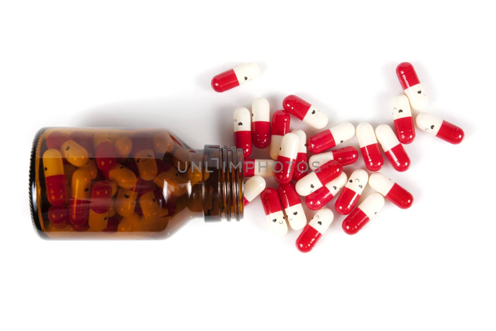 Open happy pill bottle with medicine spilling out of it isolated on white