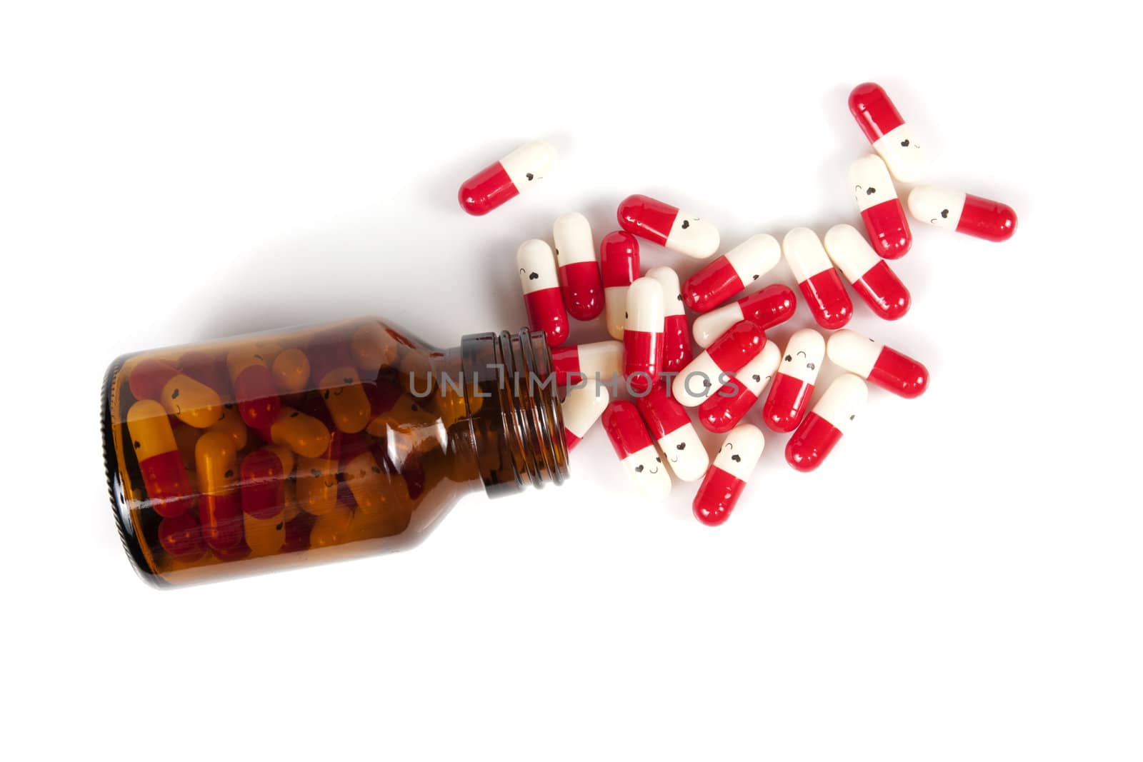 Open happy pill bottle with medicine spilling out of it isolated on white