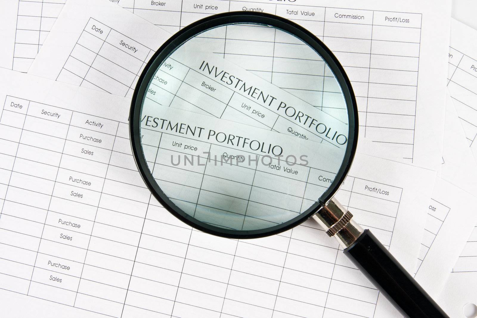 Close up stack of investment Spreadsheets and Magnifying Glass