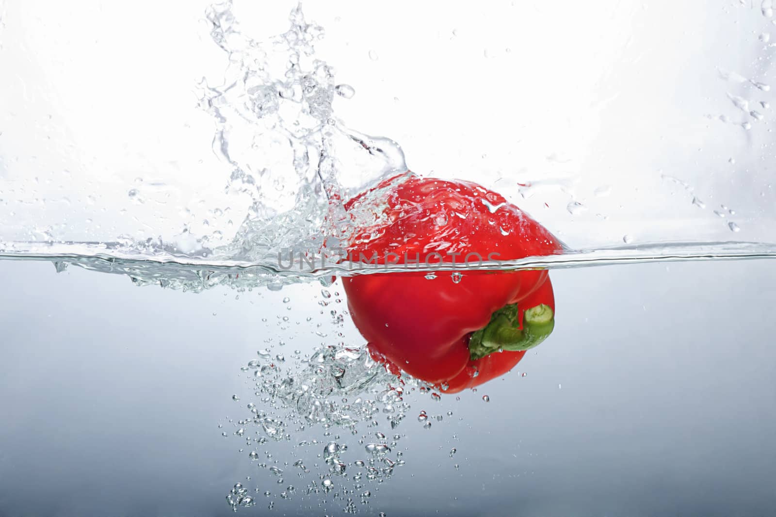 Fresh Red Bell Pepper splashing into water