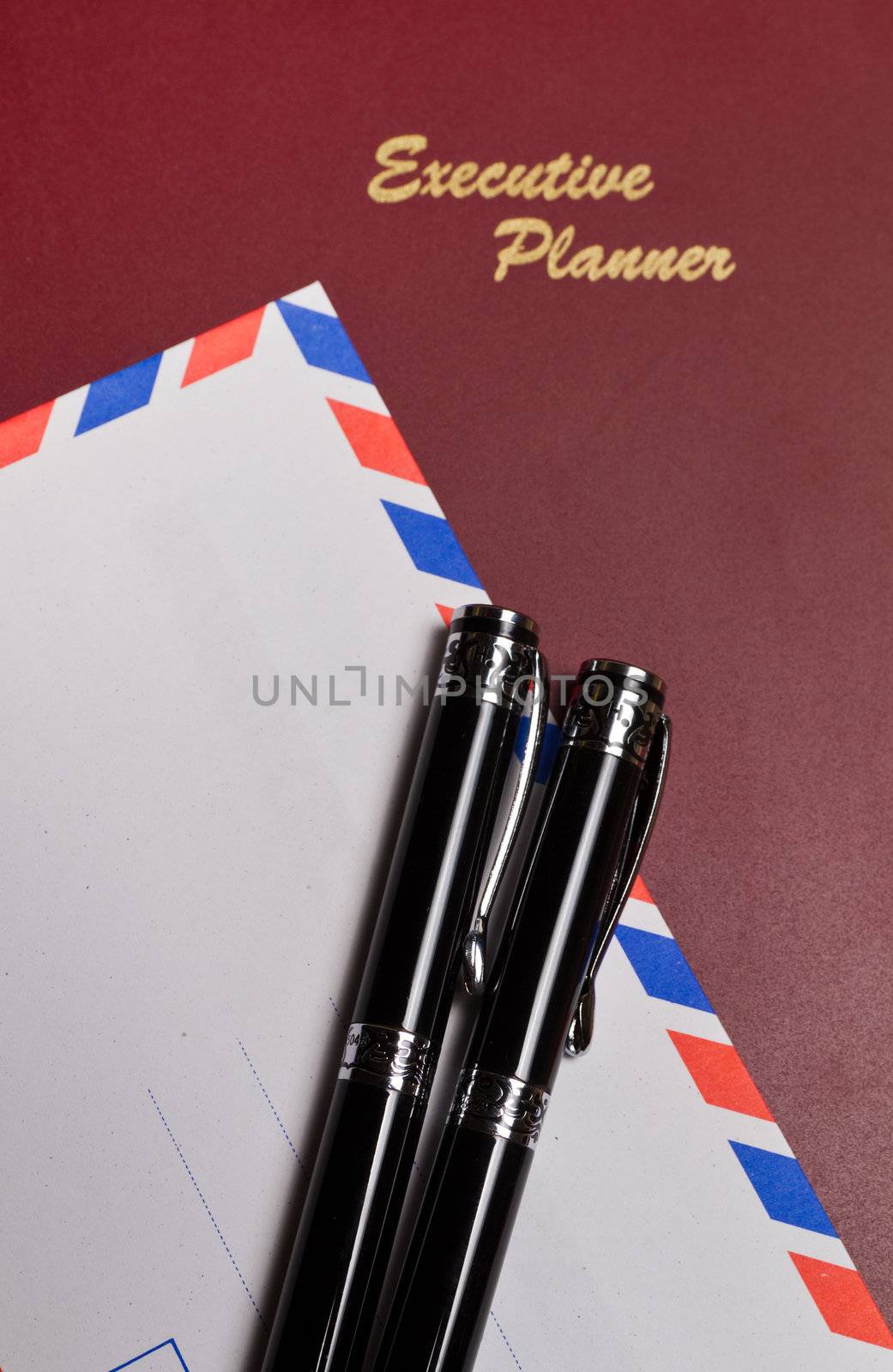 executive planner with white envelopw and pens in portrait orientation