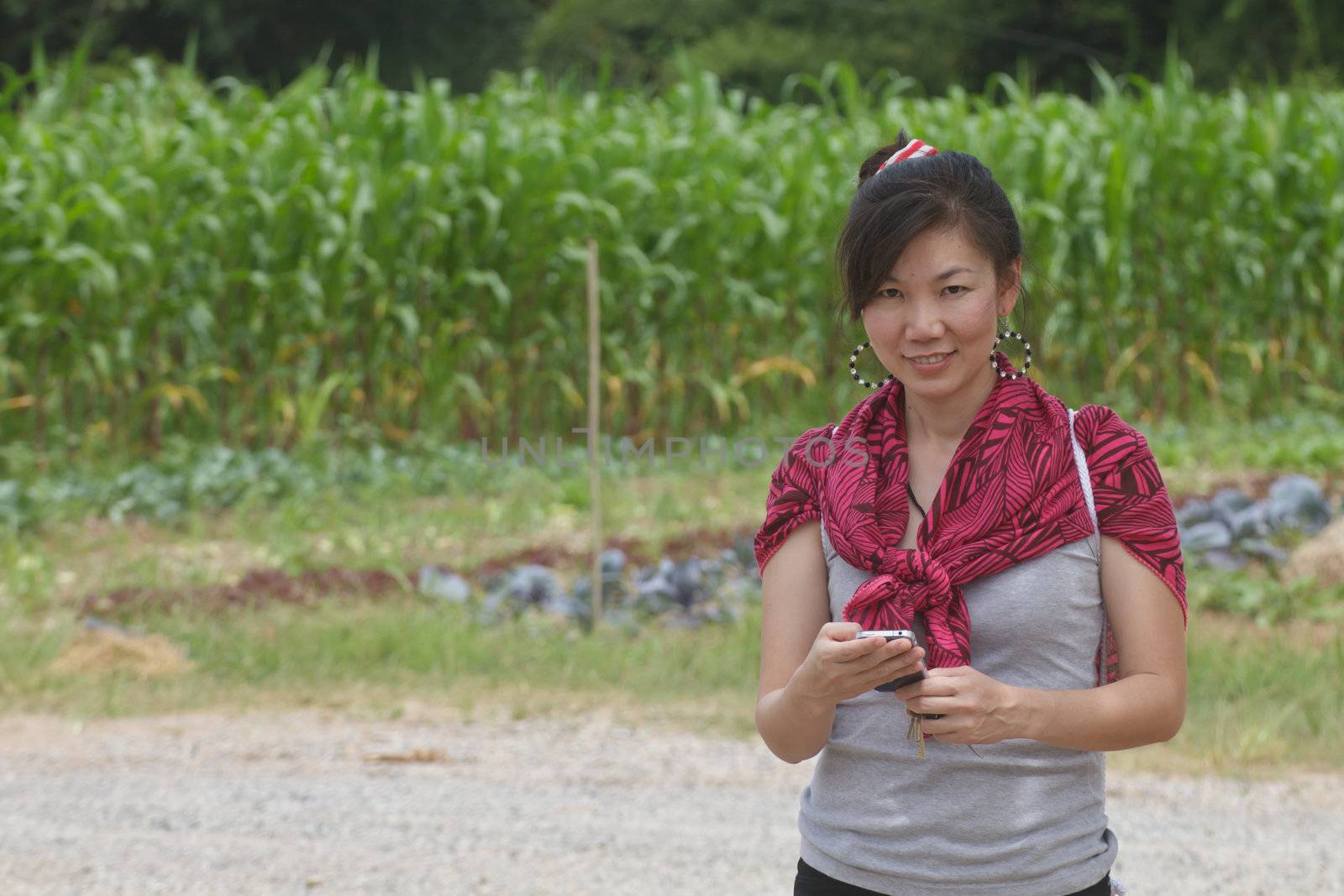 Young woman talking on a mobile against a plant background