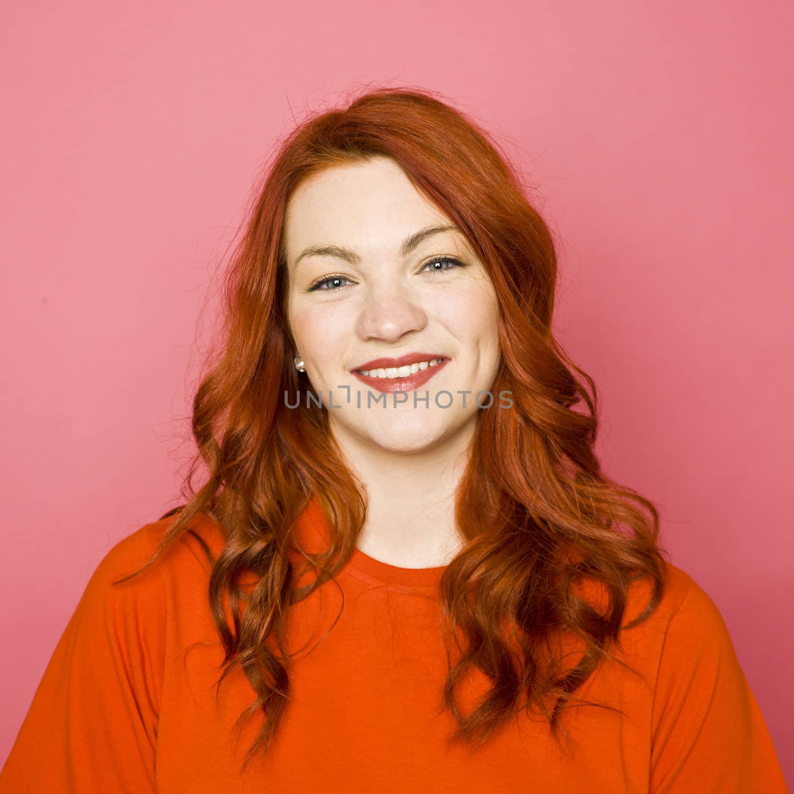 Woman with red hair on pink background