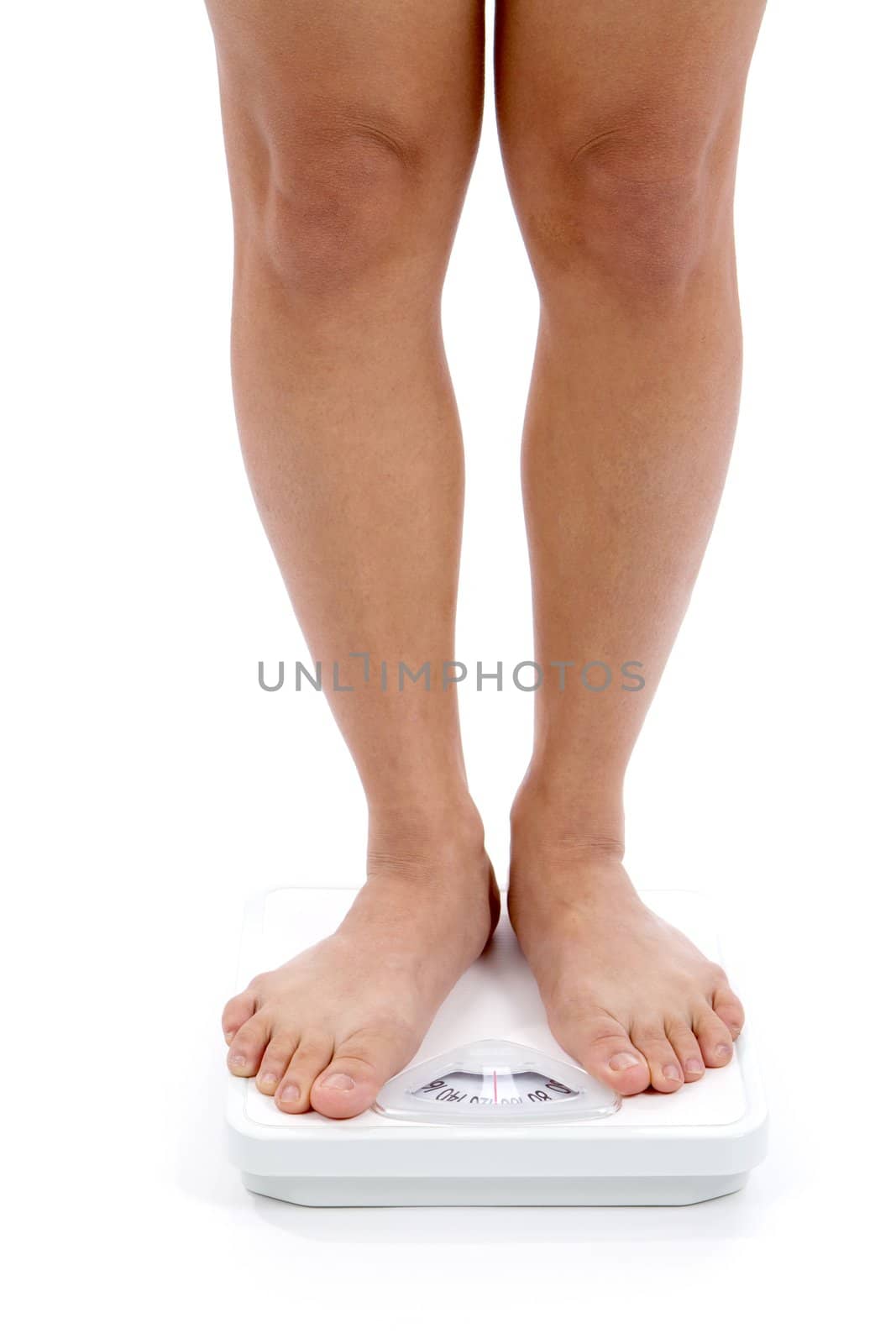 Woman's lower legs and feet shown on a bathroom scale for weightloss concept.