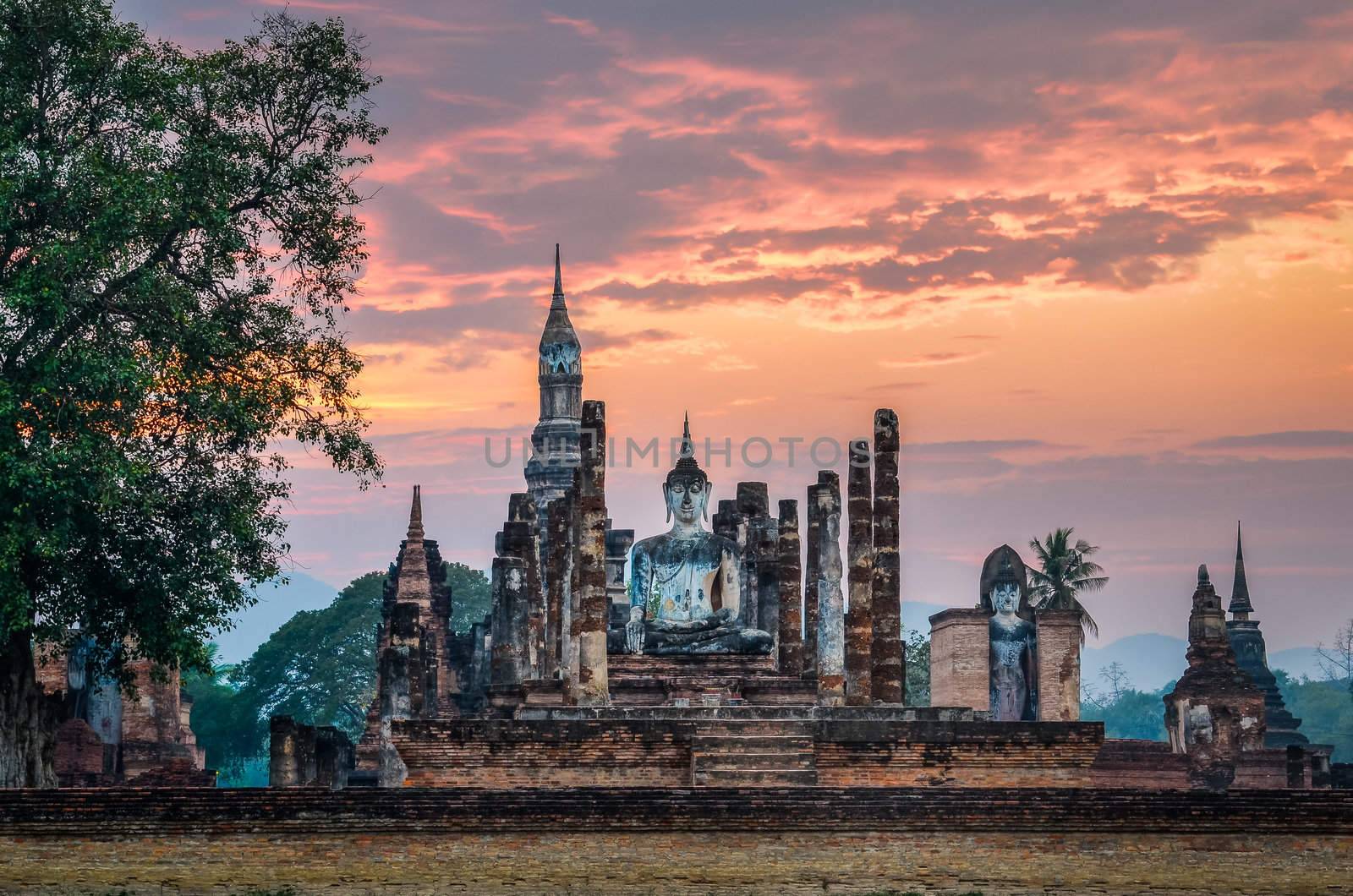 Sitting Budha at sunset in Wat Mahathat, Sukhothai historical park, Thailand