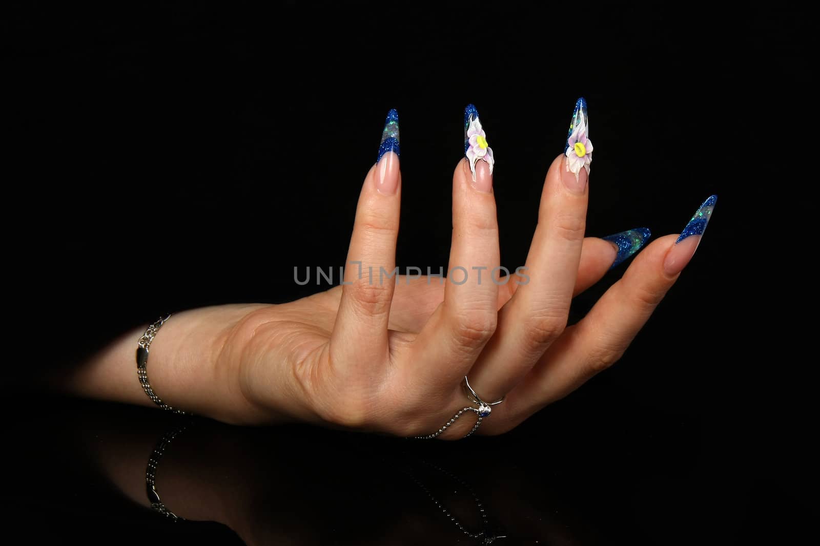 Human fingers with long fingernail and beautiful manicure isolated on black