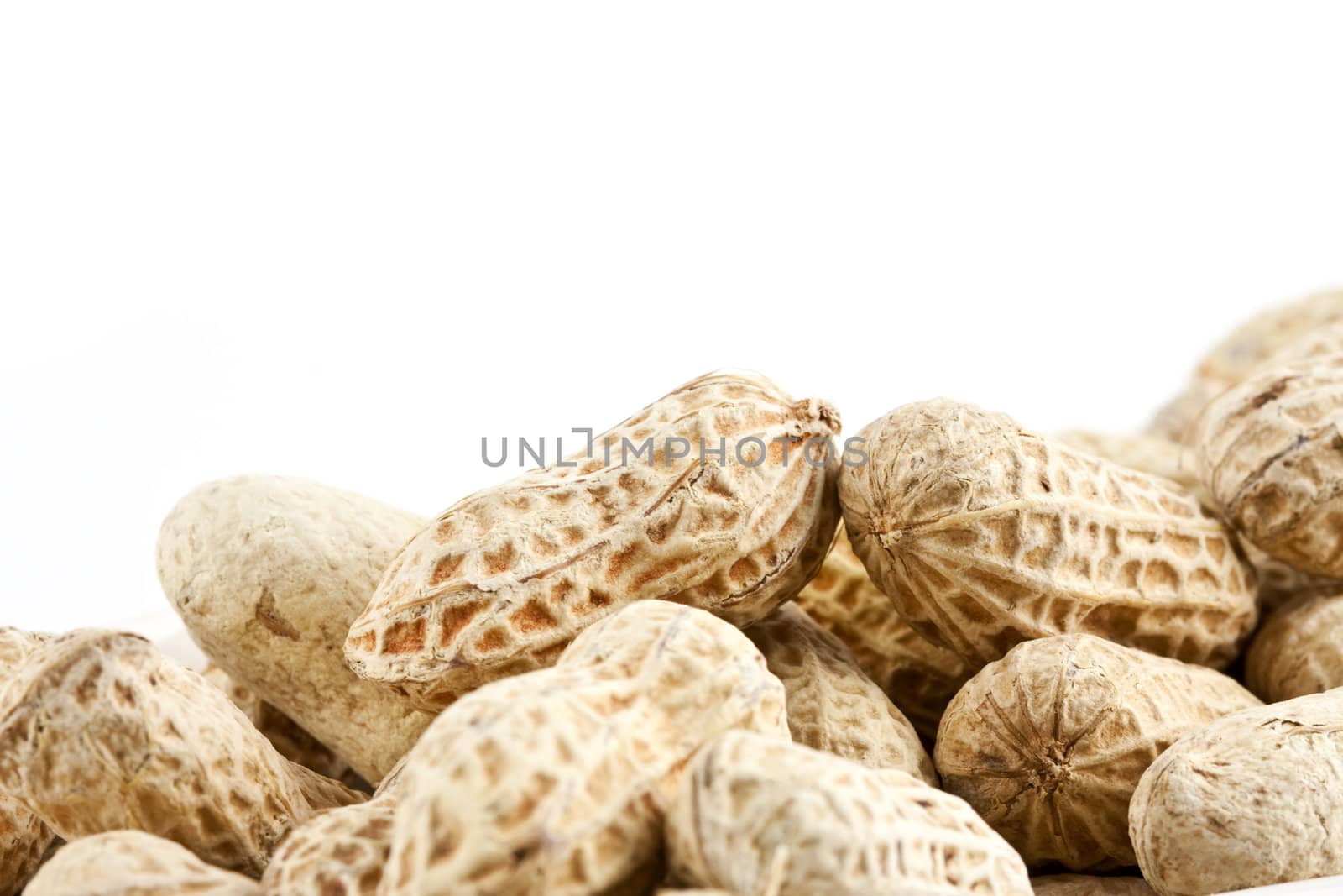 Peanut in shell snack on white plate - shallow DOF focus in the middle