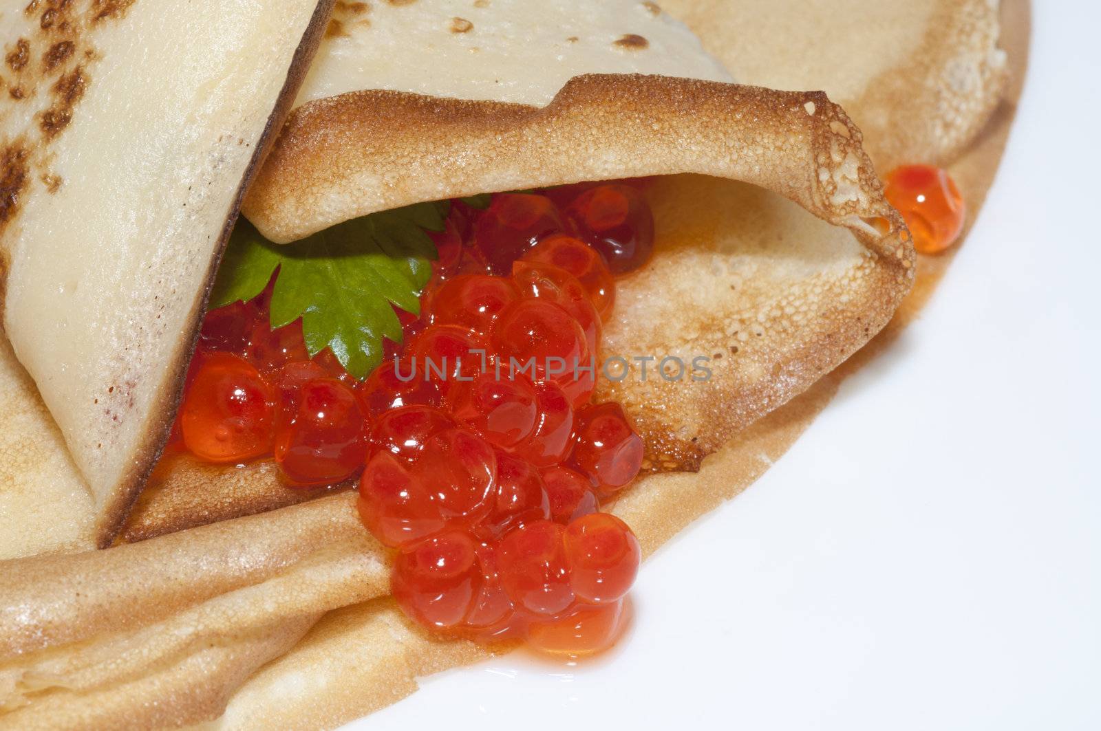 Pancake with red caviar and celery close up