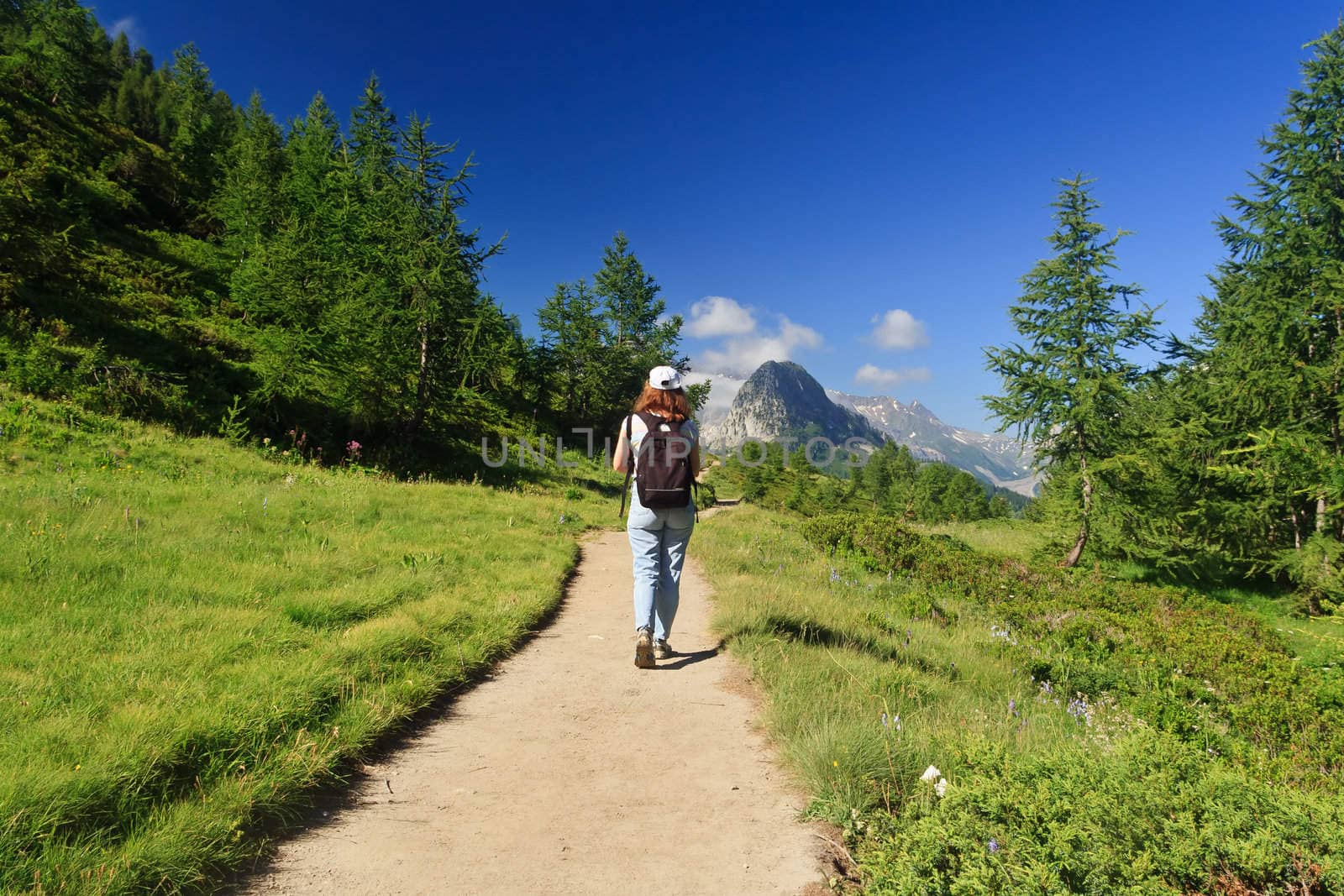 woman is walking on a pathway in Italian Alps