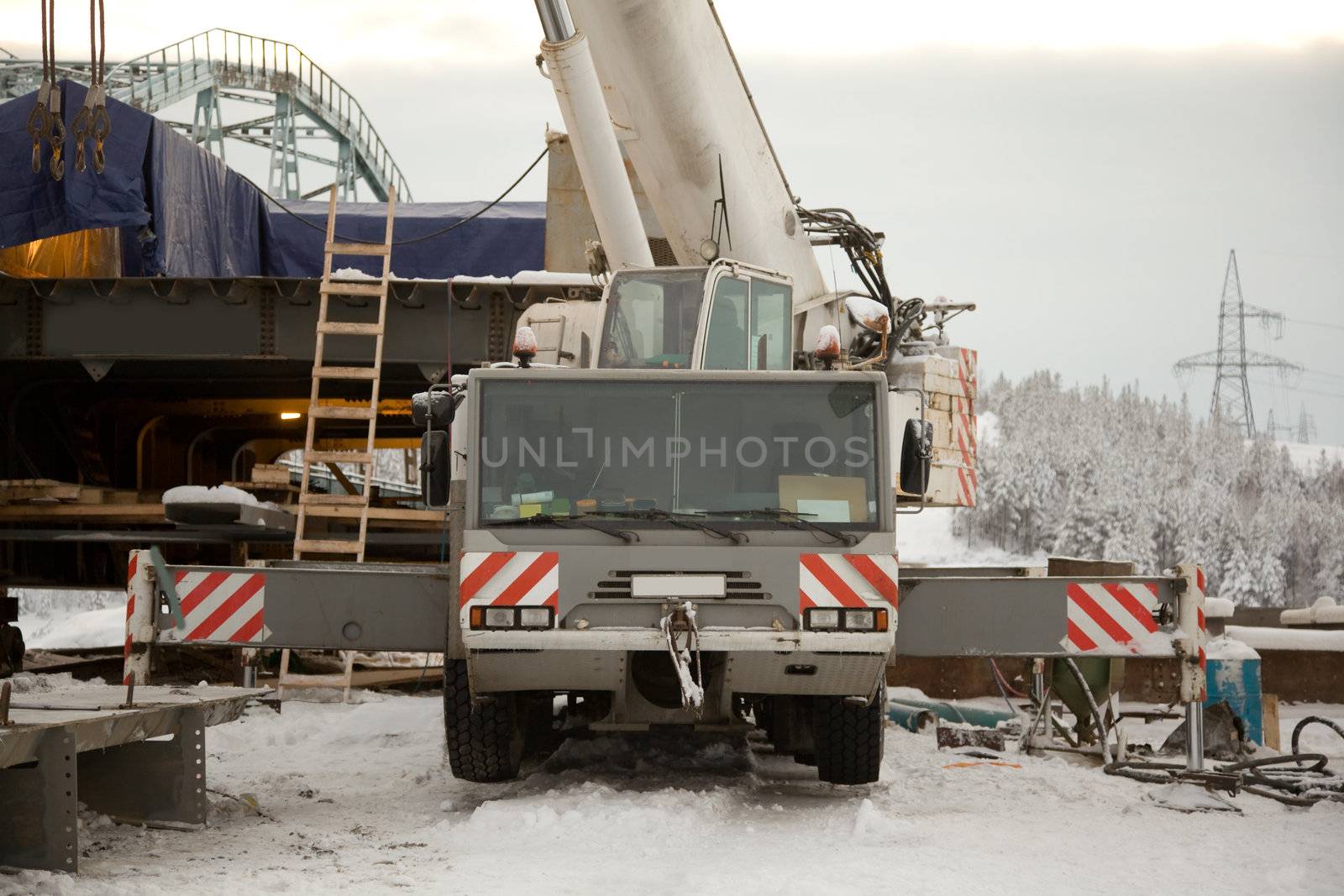 100 ton crane at the construction of the bridge. The snow. Taiga.