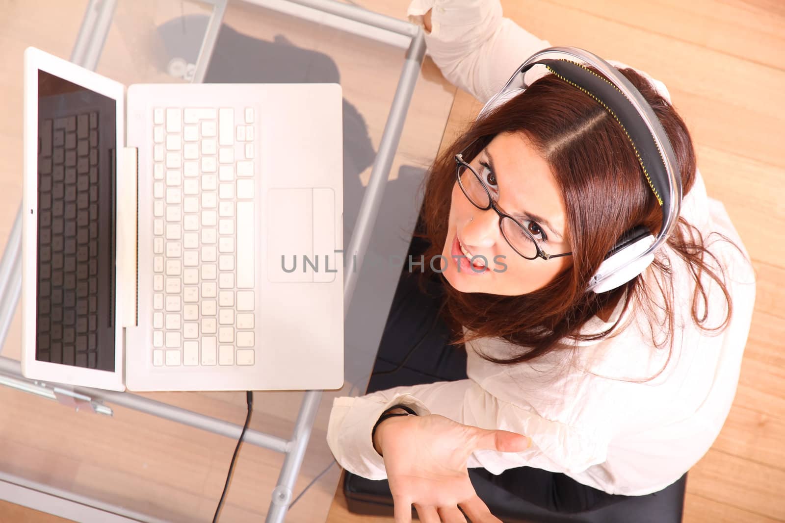 Business woman working on a Laptop while listening music with Headphones.