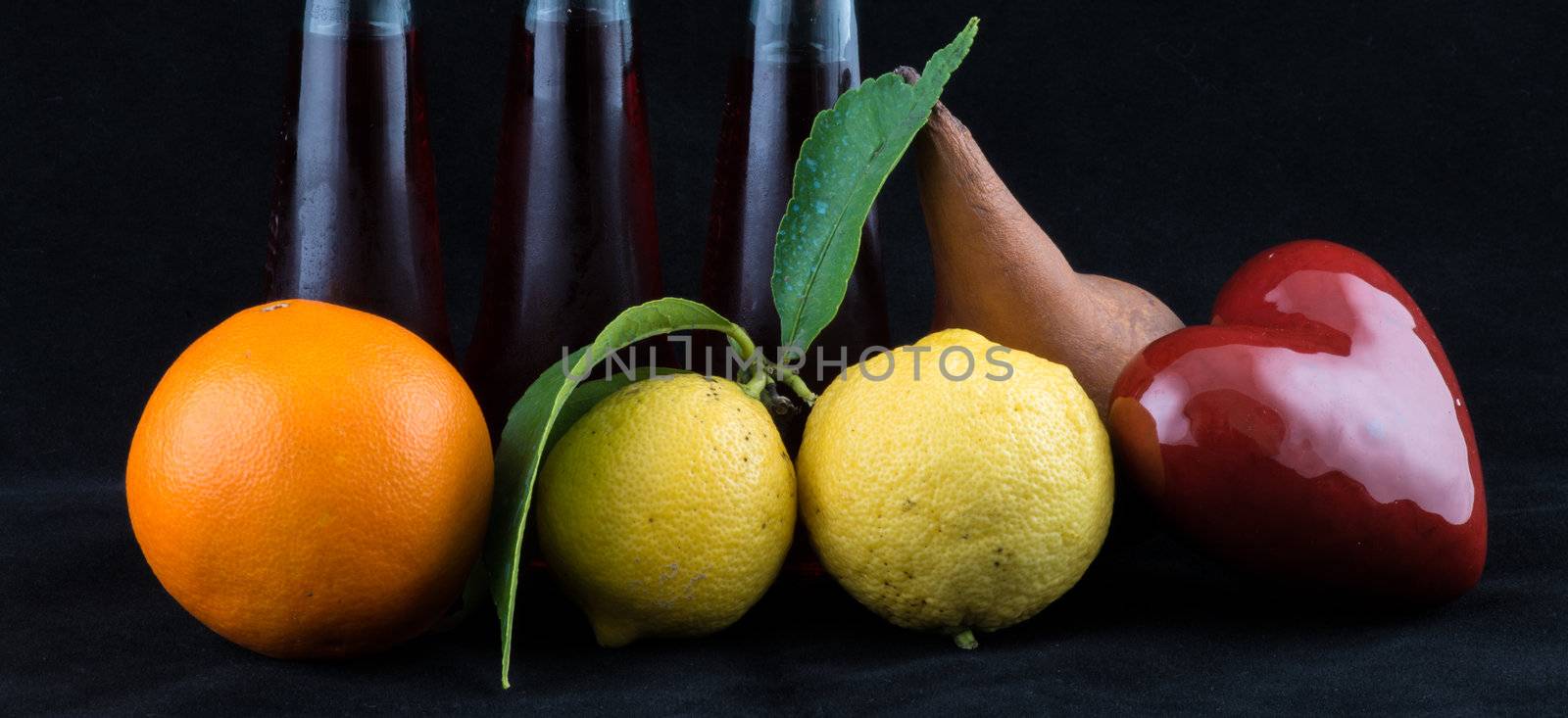 Orange, Lemon and Pear on black background.