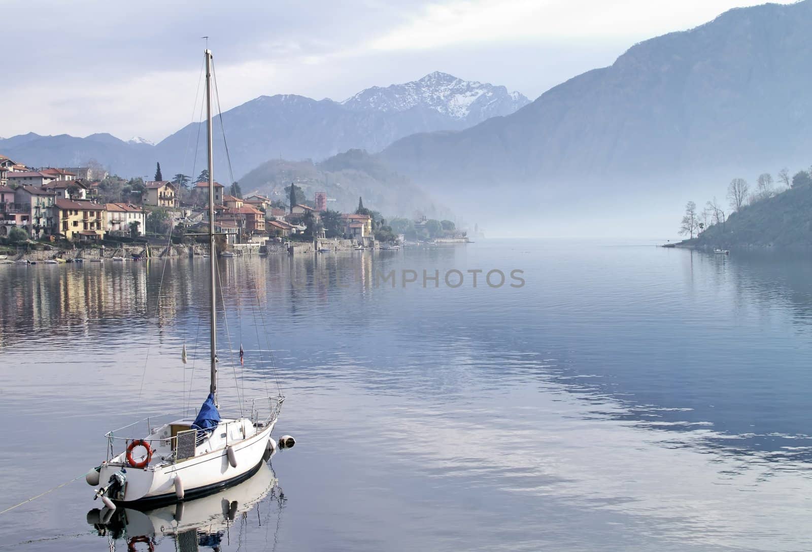 Moored sailboat in cloudy and misty day (horizontall) - Como Italy by Laborer