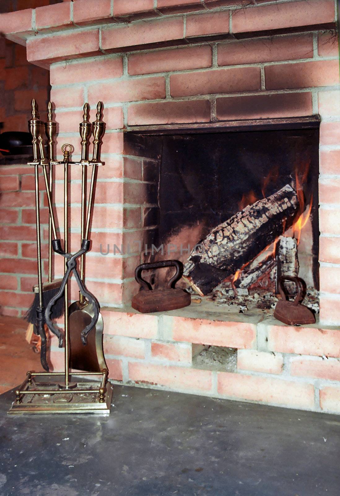 Fireplace with two old irons in it by mulden