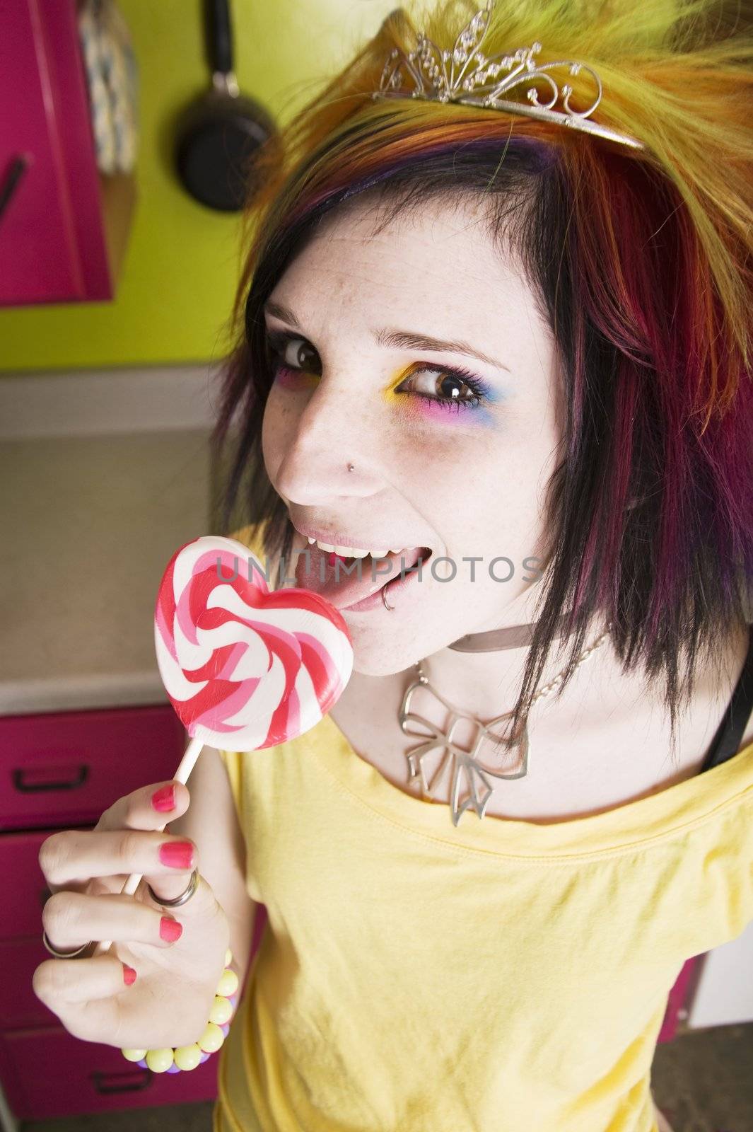 Alternative Girl in a Colorful Kitchen with a Heart Lollipop