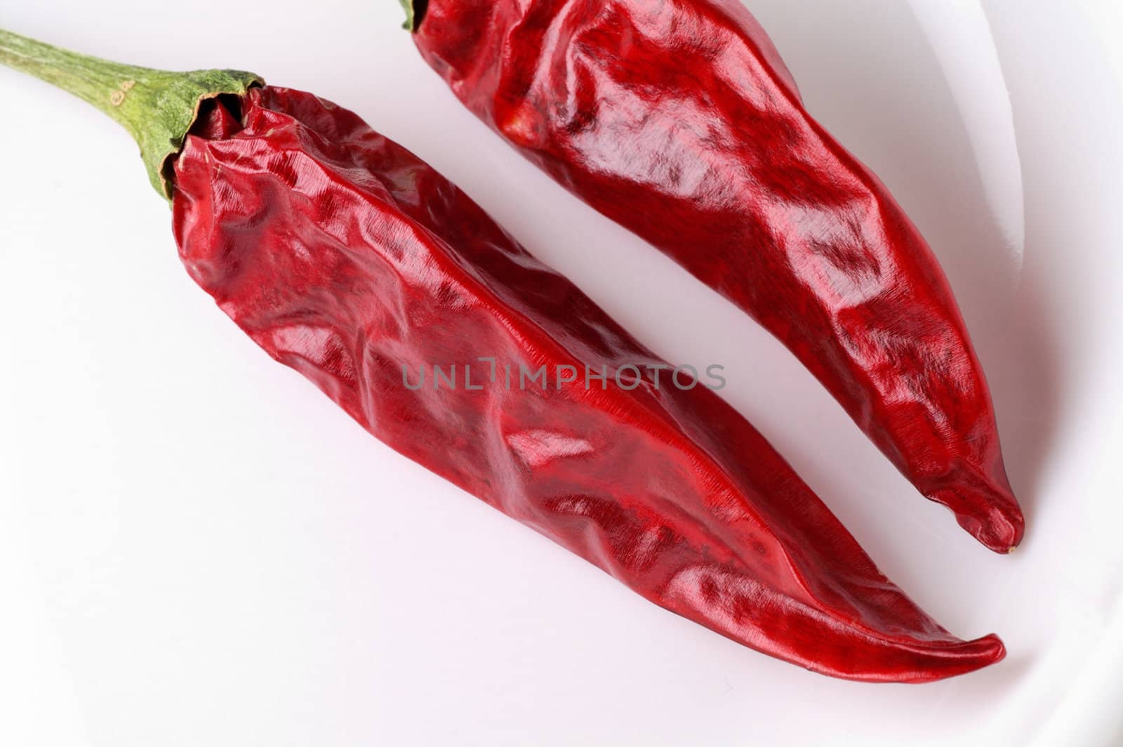 Dried red hot peppers on dish closeup by Laborer