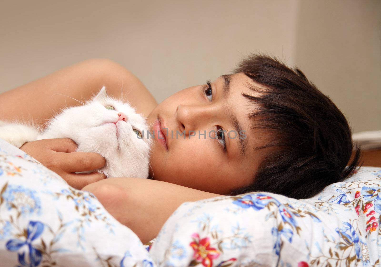 asian boy with white cat lieng in bed
