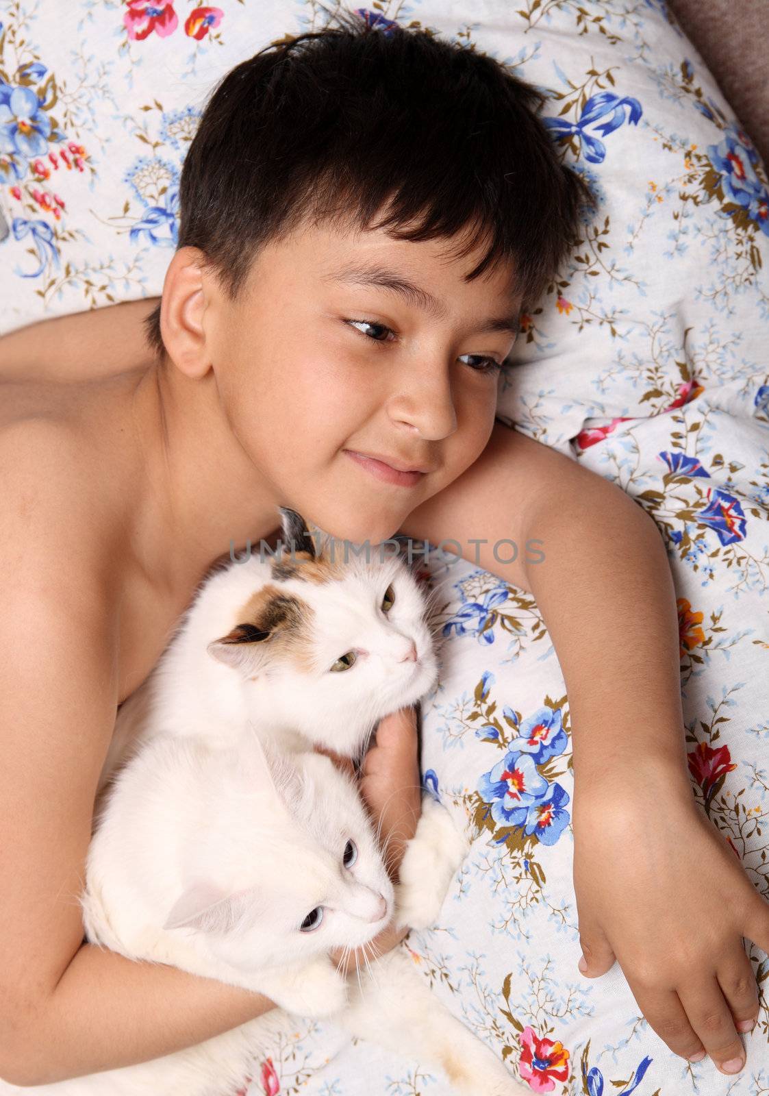 happy asian boy with cats lieng in bed
