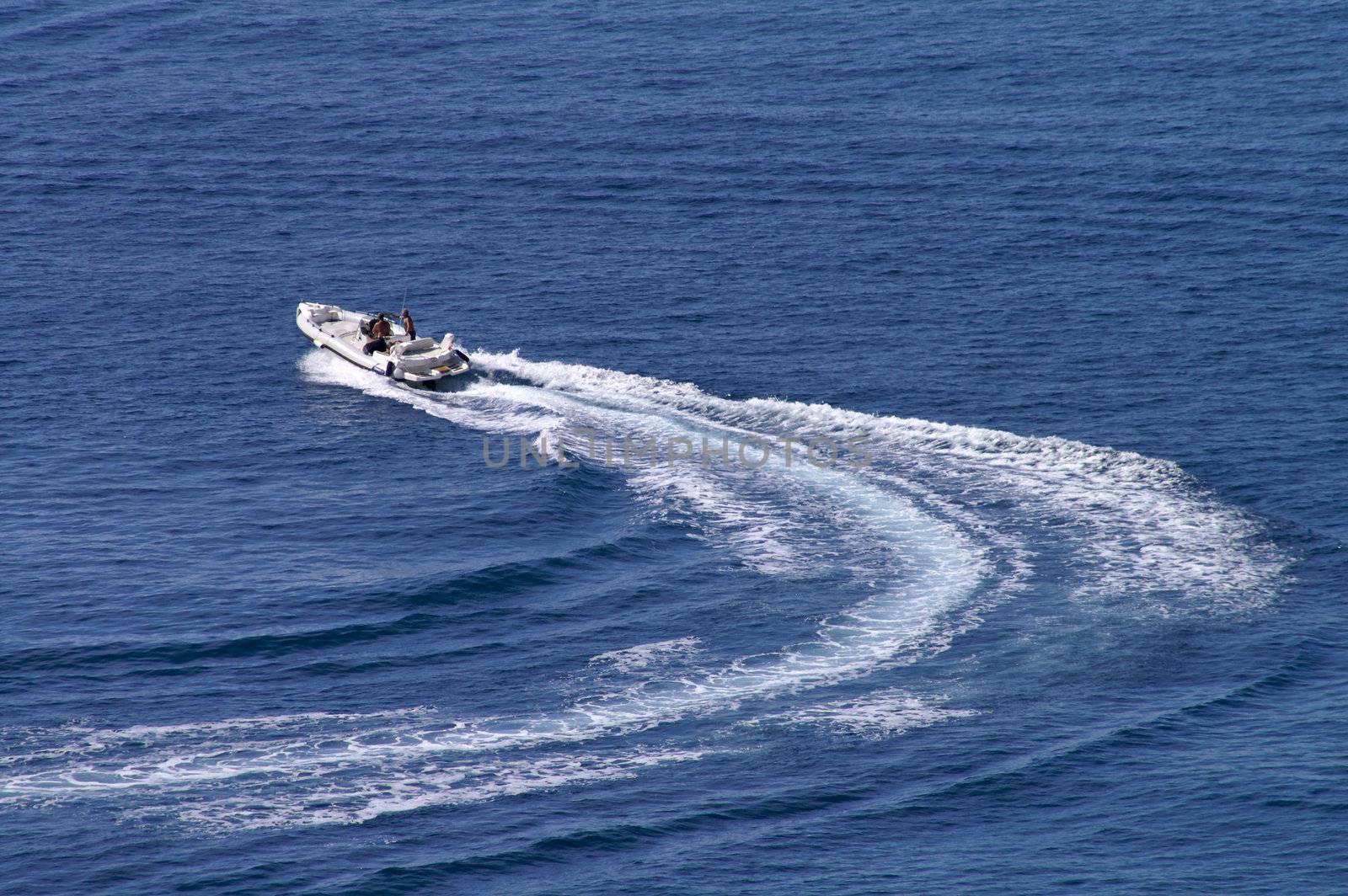 Motorboat changing course  at full power leaving curved wake behind
