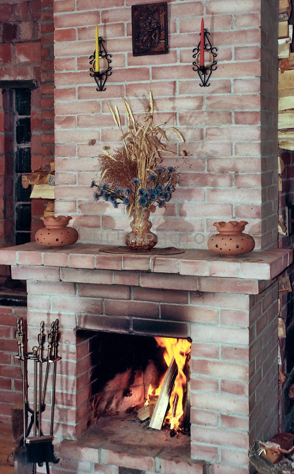 Village kitchen fireplace with dead flowers on mantelshelf