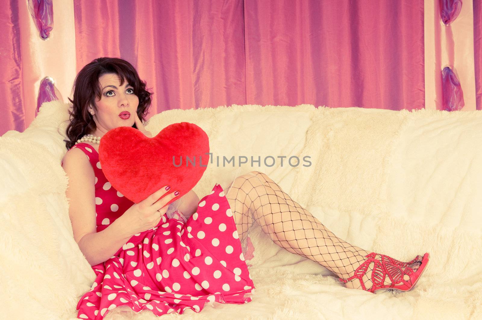 woman pin-up in red dress sit on the sofa