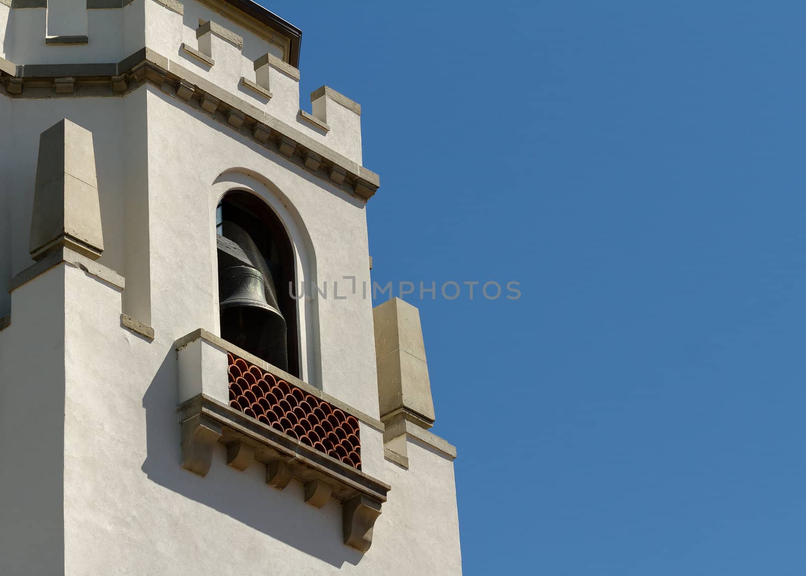 Older bell tower style building against a blue sky