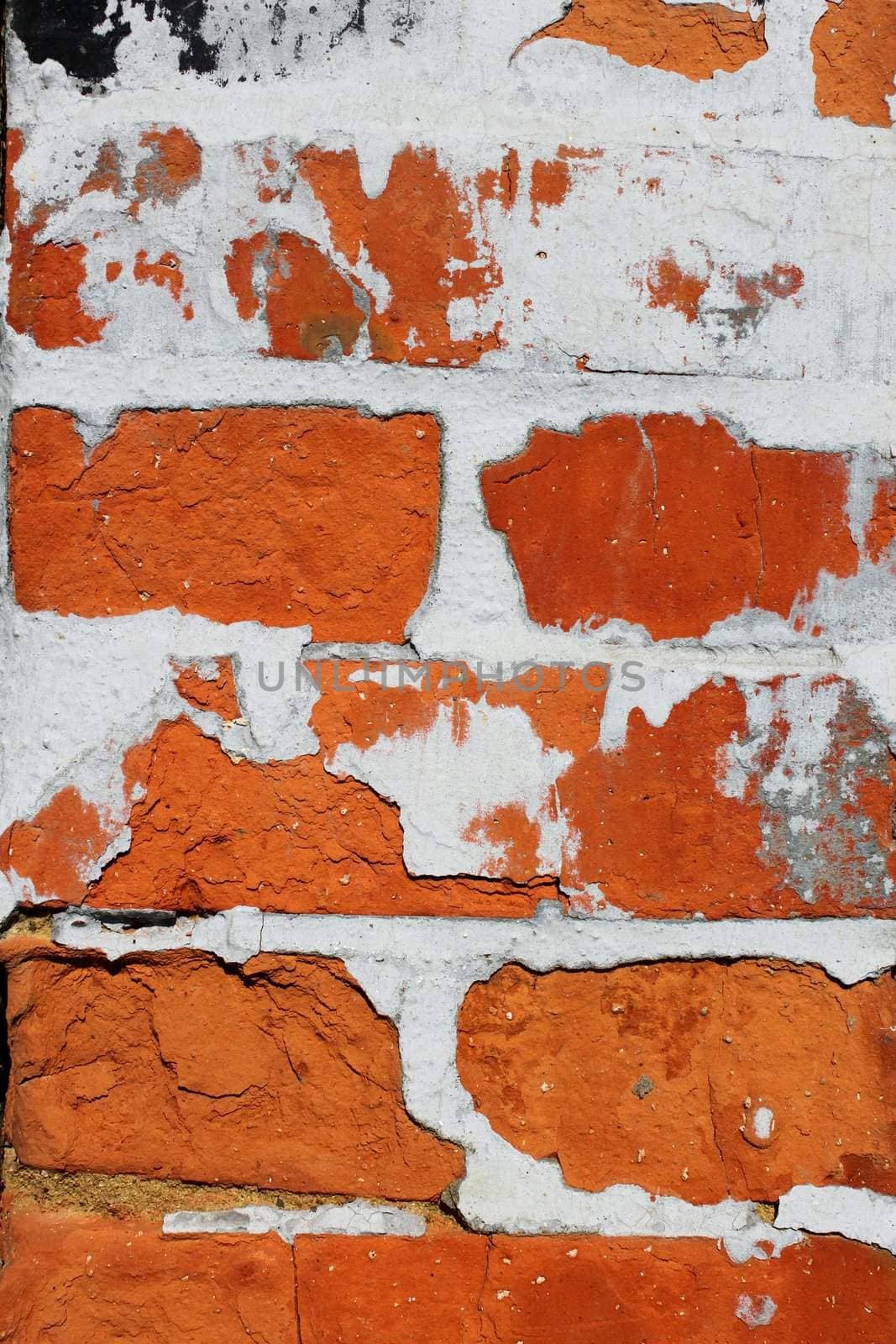 Fragment of old brick wall with concrete covering shelled close up