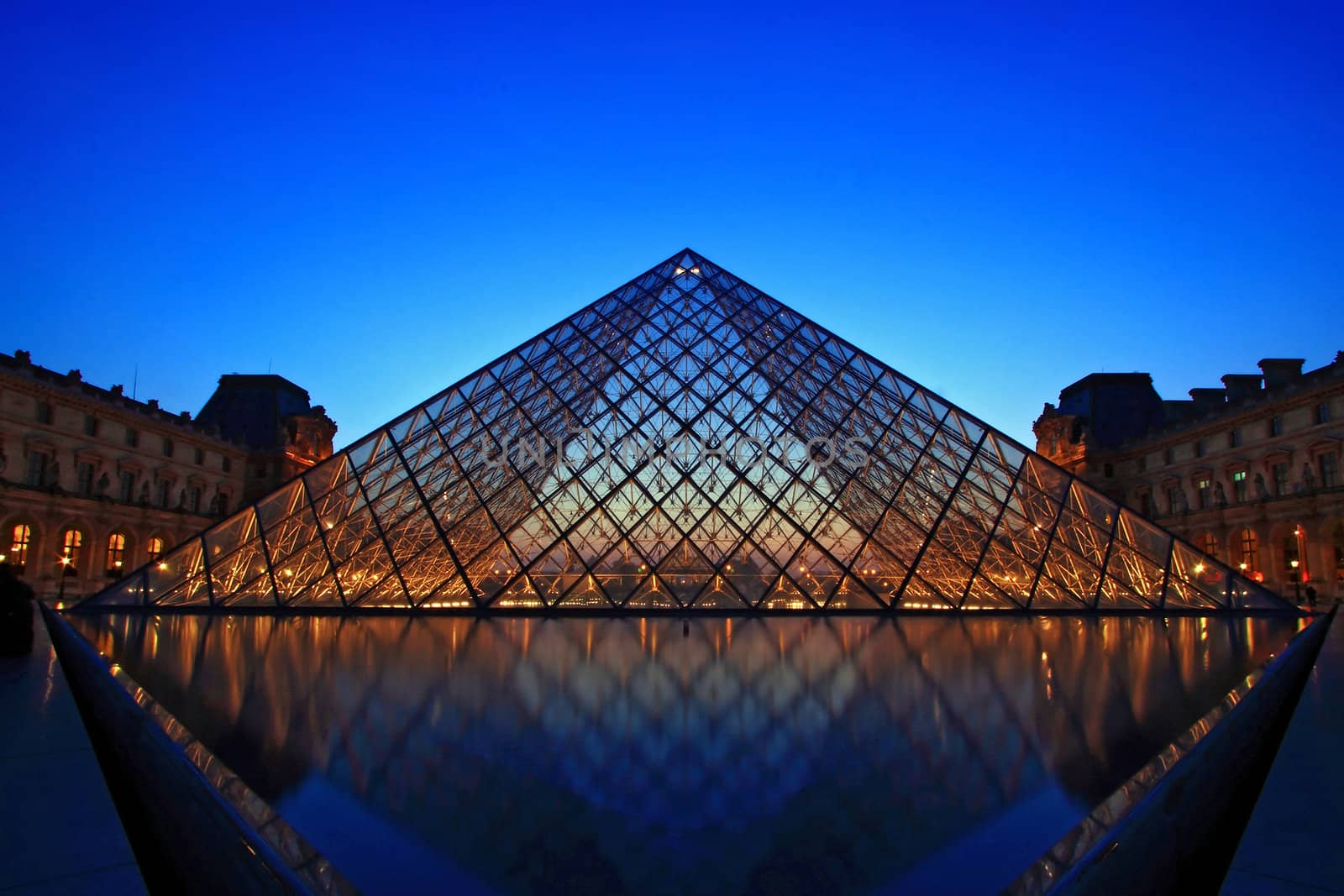 PARIS - APRIL 16: Shining of Louvre pyramid at Evening during the Egyptian Antiquities Summer Exhibition April 16, 2010 in Paris. This is one of the most popular tourist destinations in France.