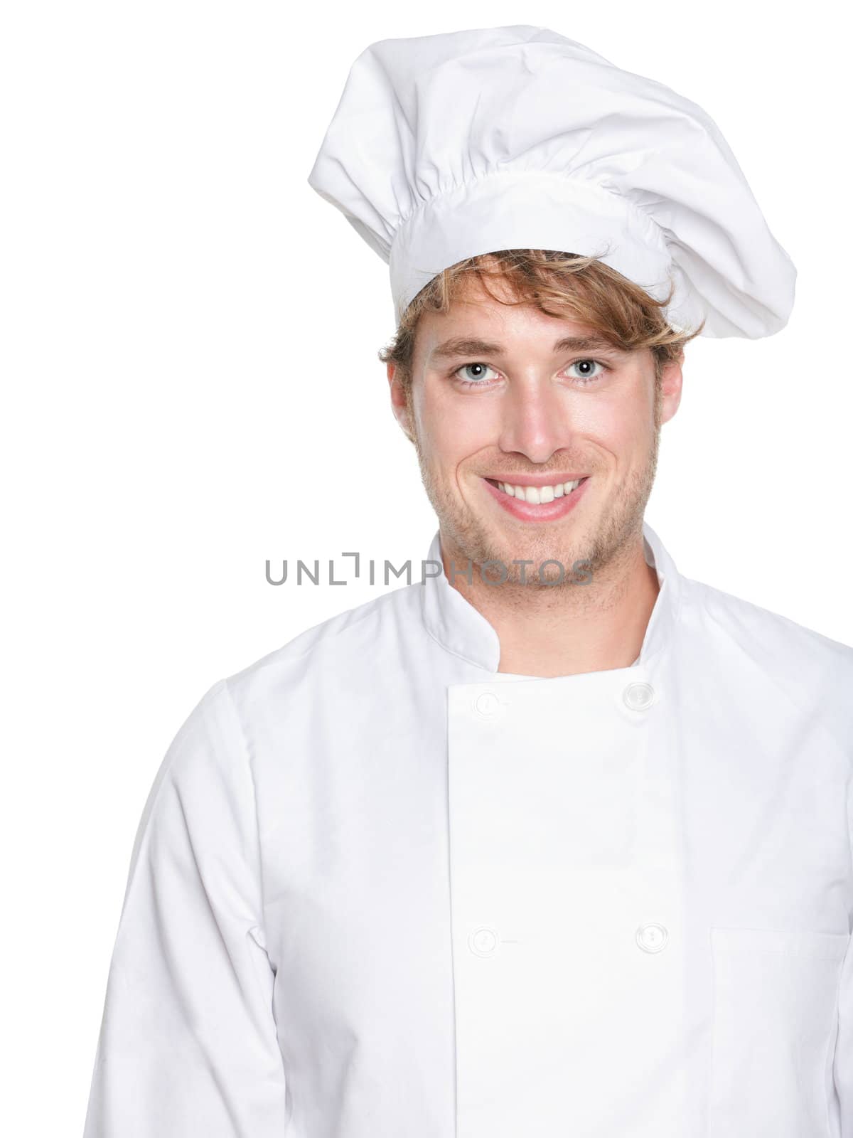 Chef, baker or male cook. Young man in chefs whites uniform smiling happy at camera. Portrait of young chef in his twenties.