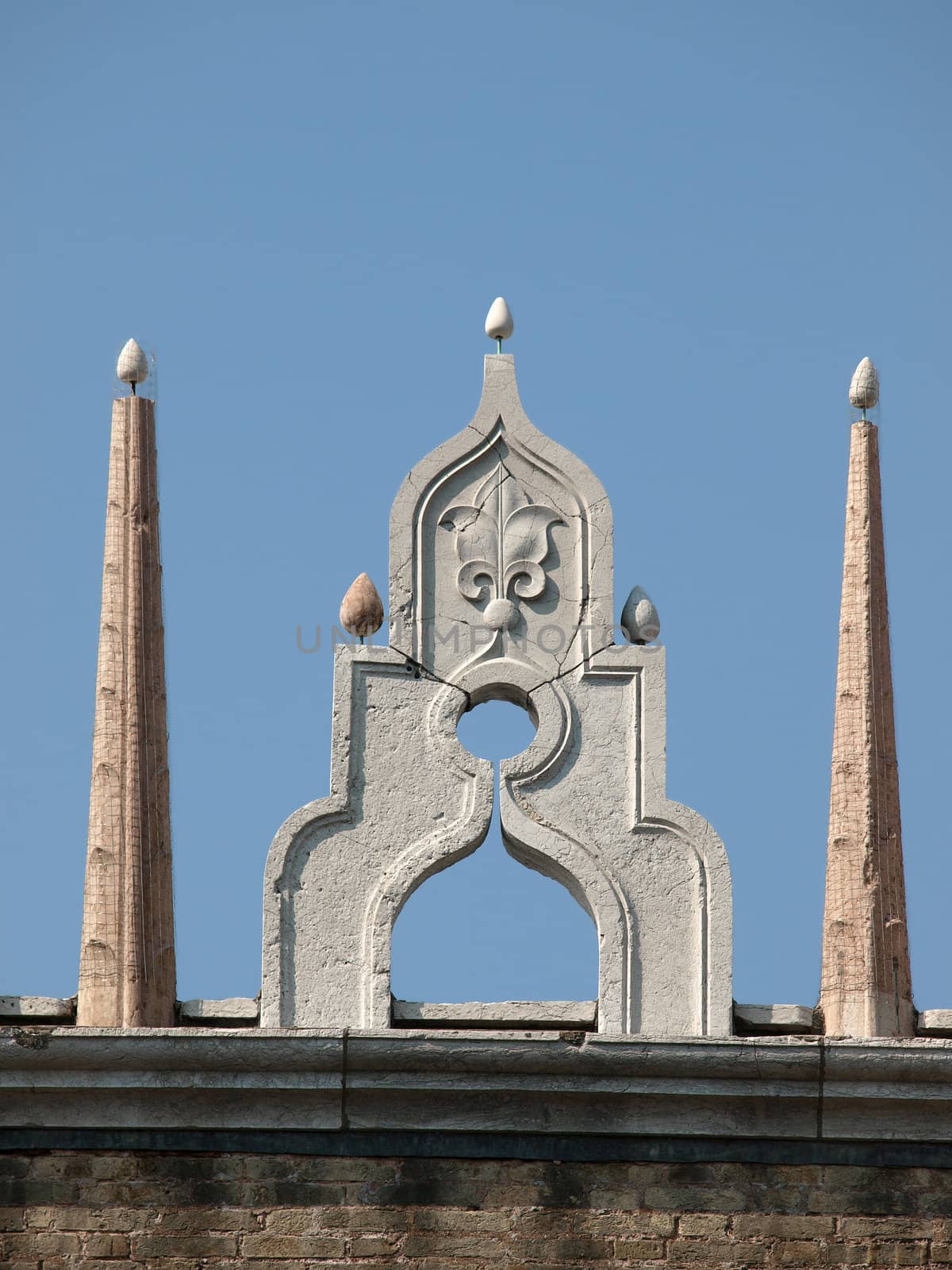 Venice - characteristic architectural ornaments on the edge of a roof of the Palace of Doges.  These are they at the top and the colonnade at the bottom are granting this unique rhythm this building