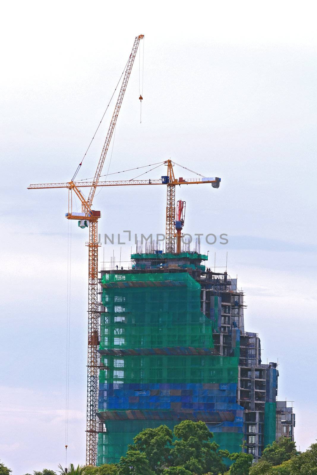 Skyscraper Office Tower Under Construction with two Cranes in Pattaya Thailand
