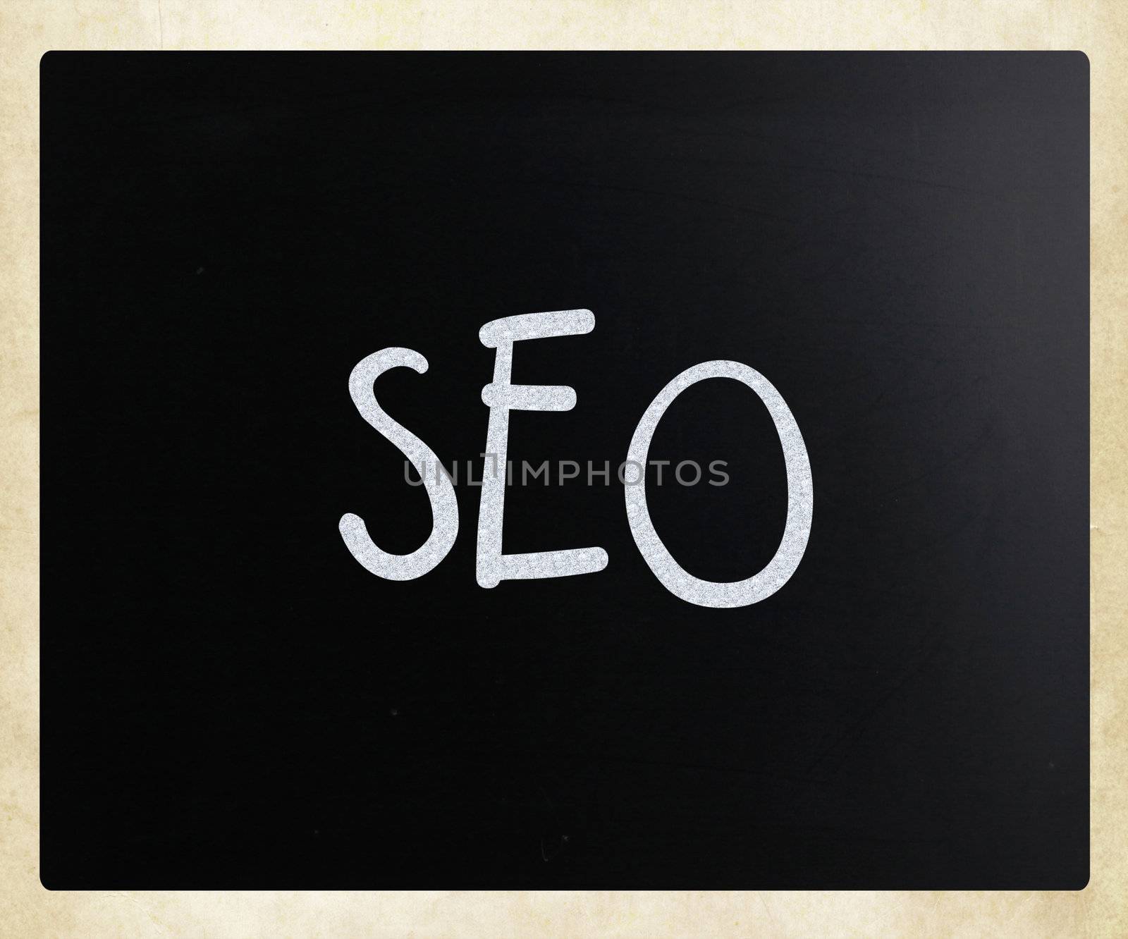The word "SEO" handwritten with white chalk on a blackboard by nenov