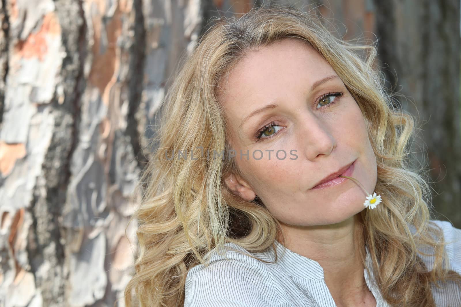 Woman with a daisy in her mouth by phovoir