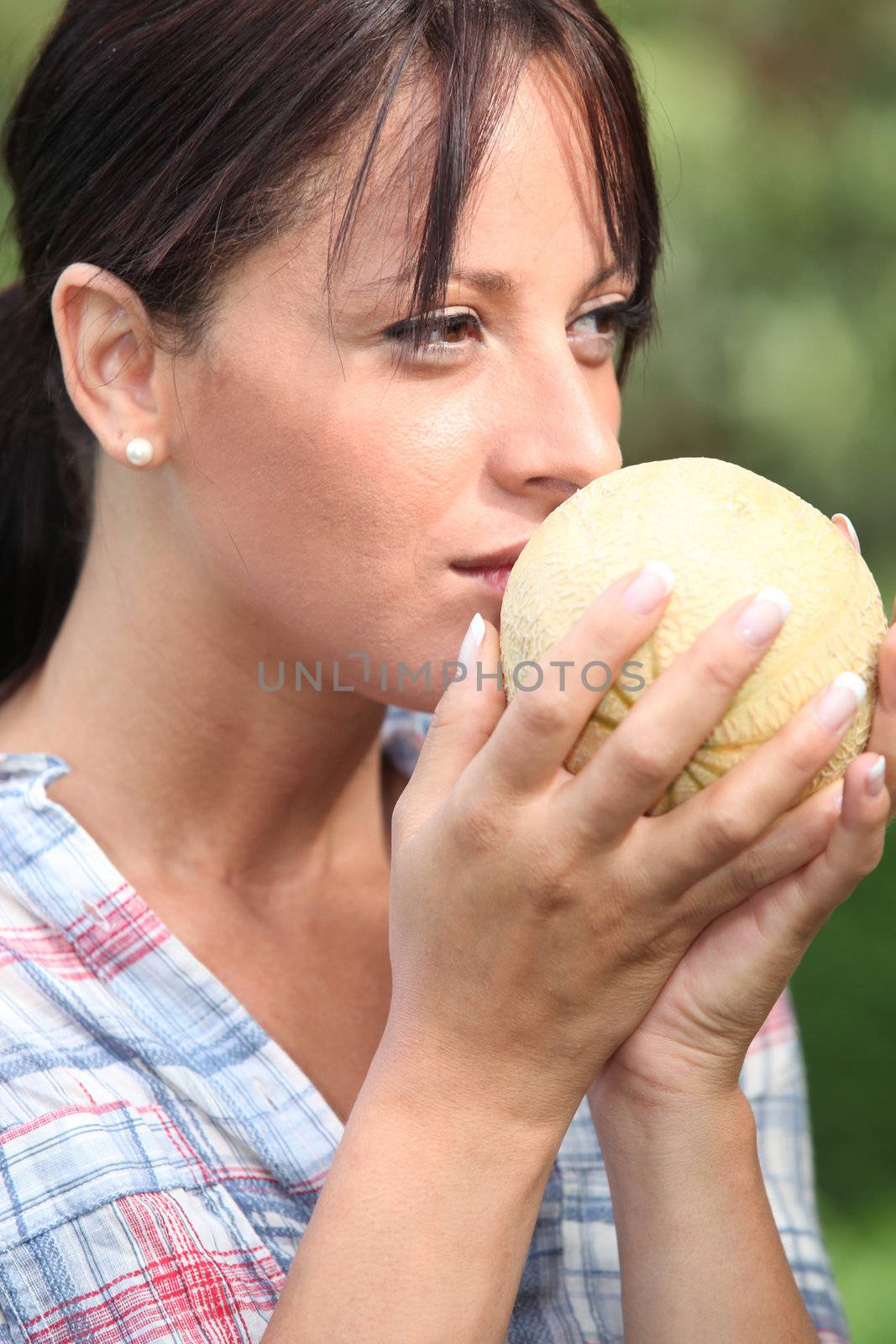 Young woman smelling a melon