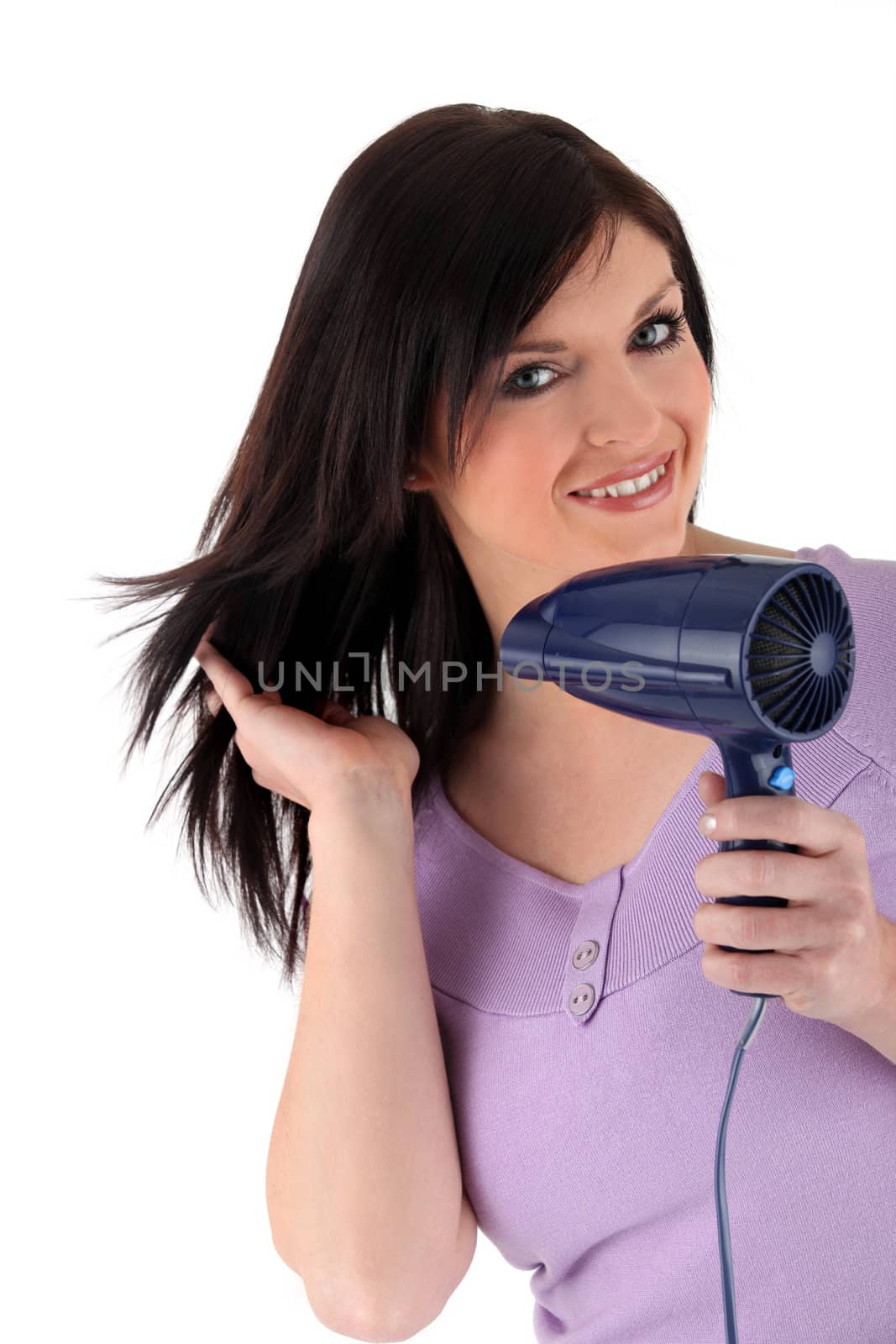Studio image of a woman using a hairdryer by phovoir