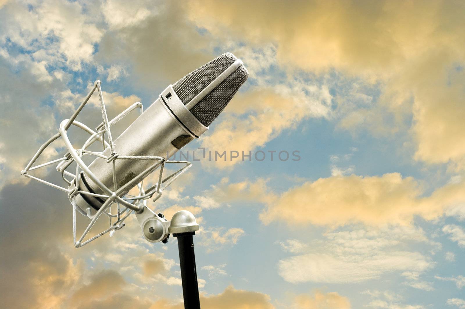 Microphone and cloudy sky at sunset time