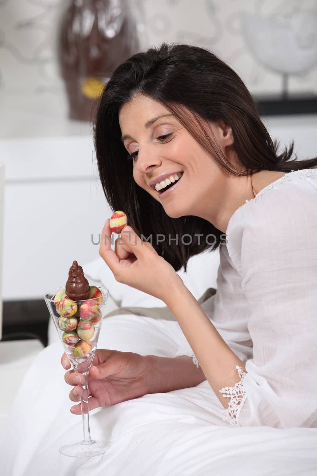 Cheerful woman eating Easter eggs by phovoir