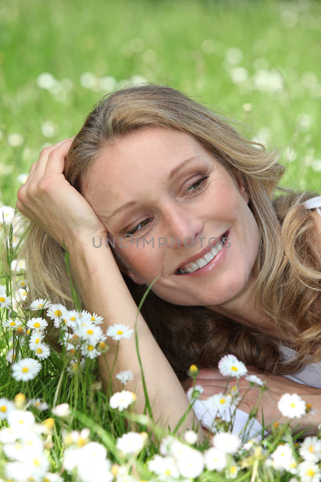 Closeup of smiling woman amongst the daisies by phovoir