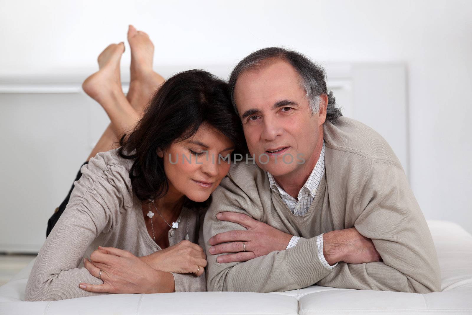 Married couple laying in bed by phovoir