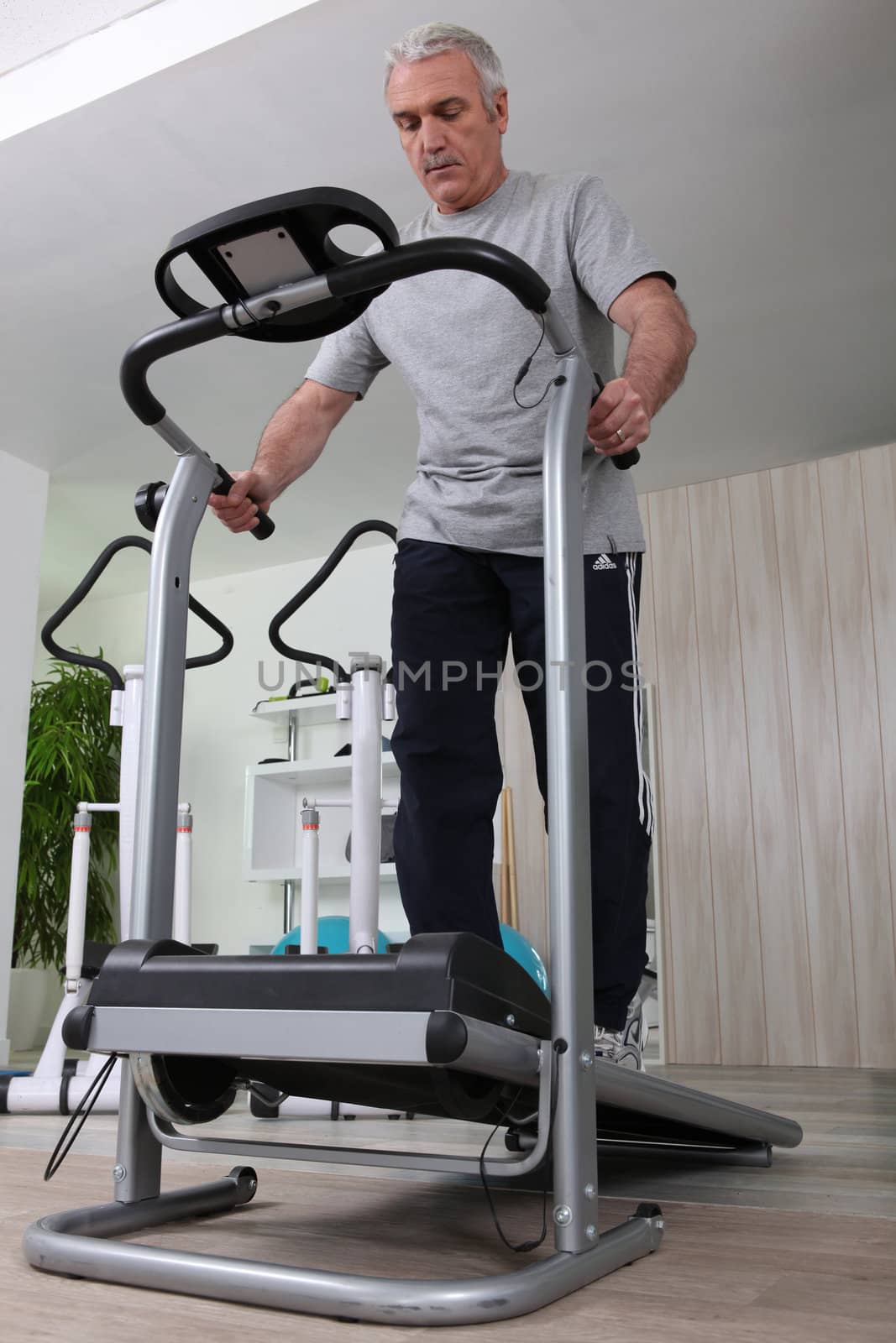 Middle-aged man jogging in gym