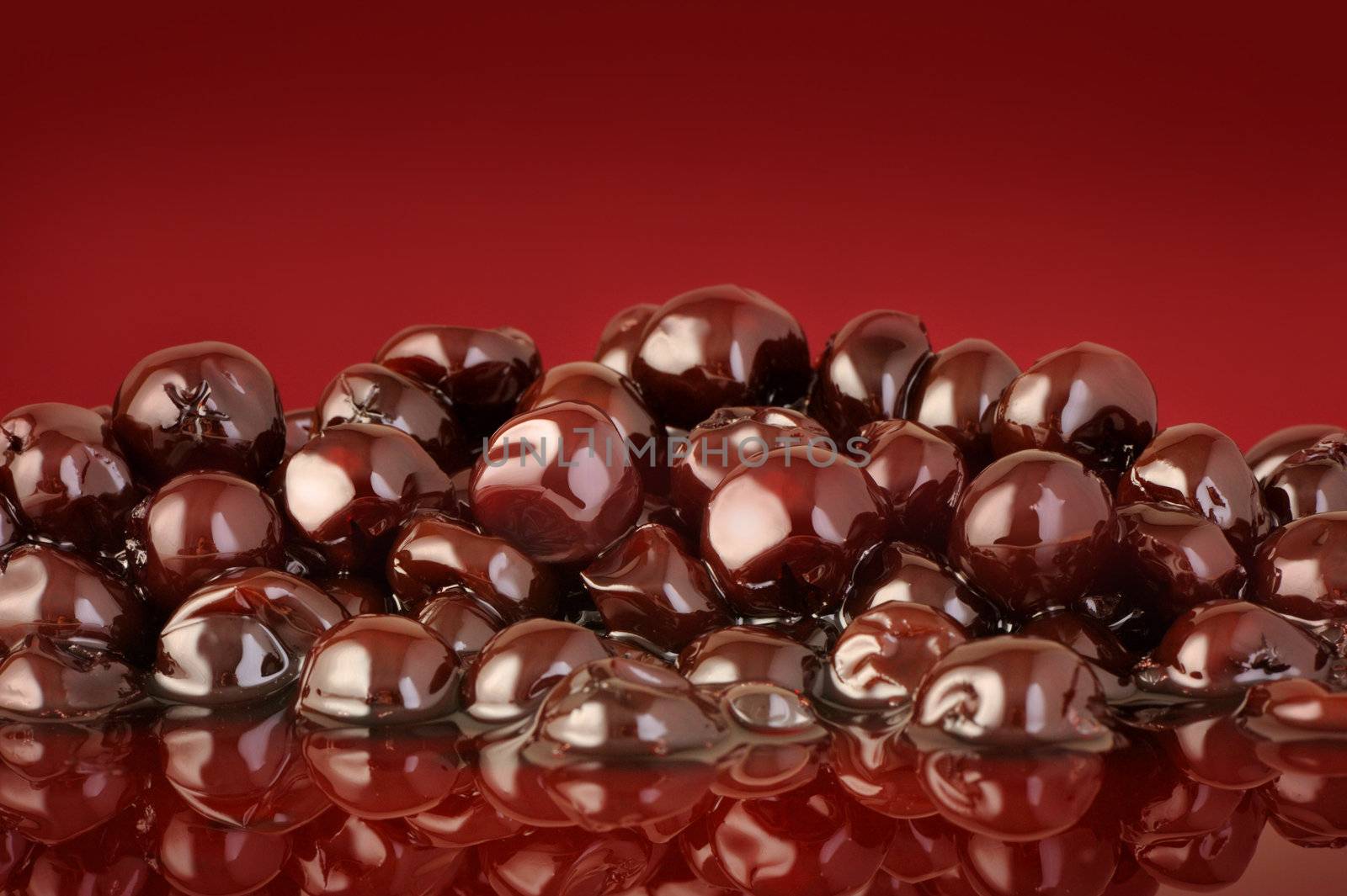 black cherry on red background by stokkete