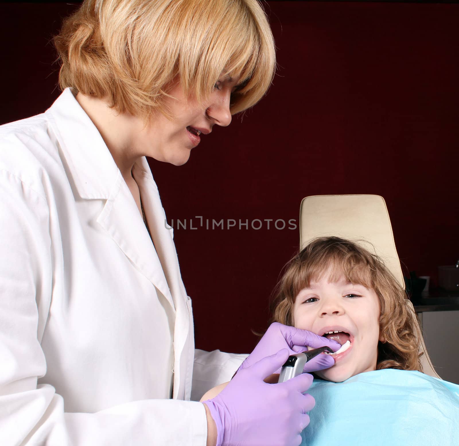 female dentist and little girl patient by goce
