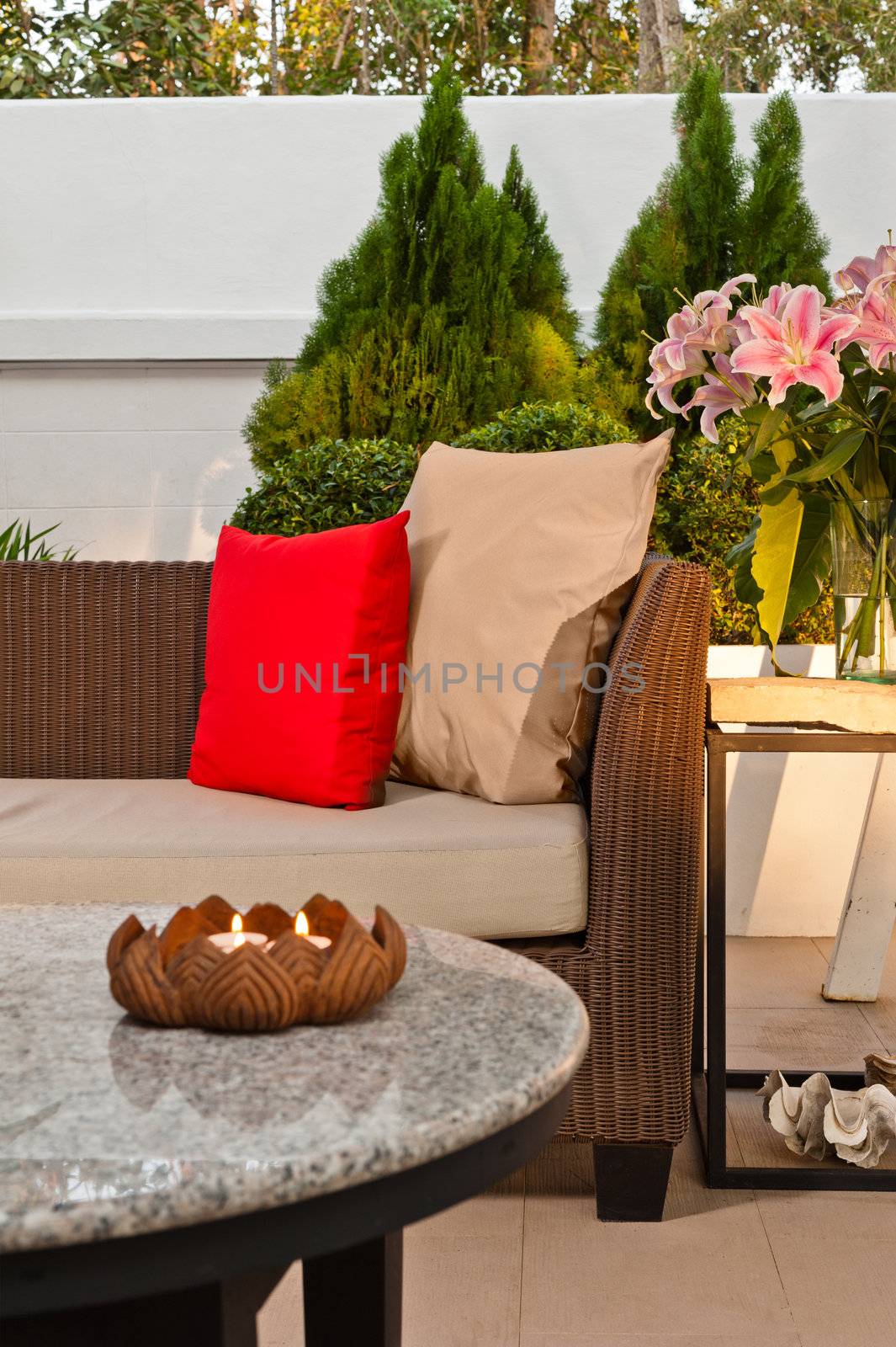 Outdoor patio seating are with nice Rattan sofa at sunset