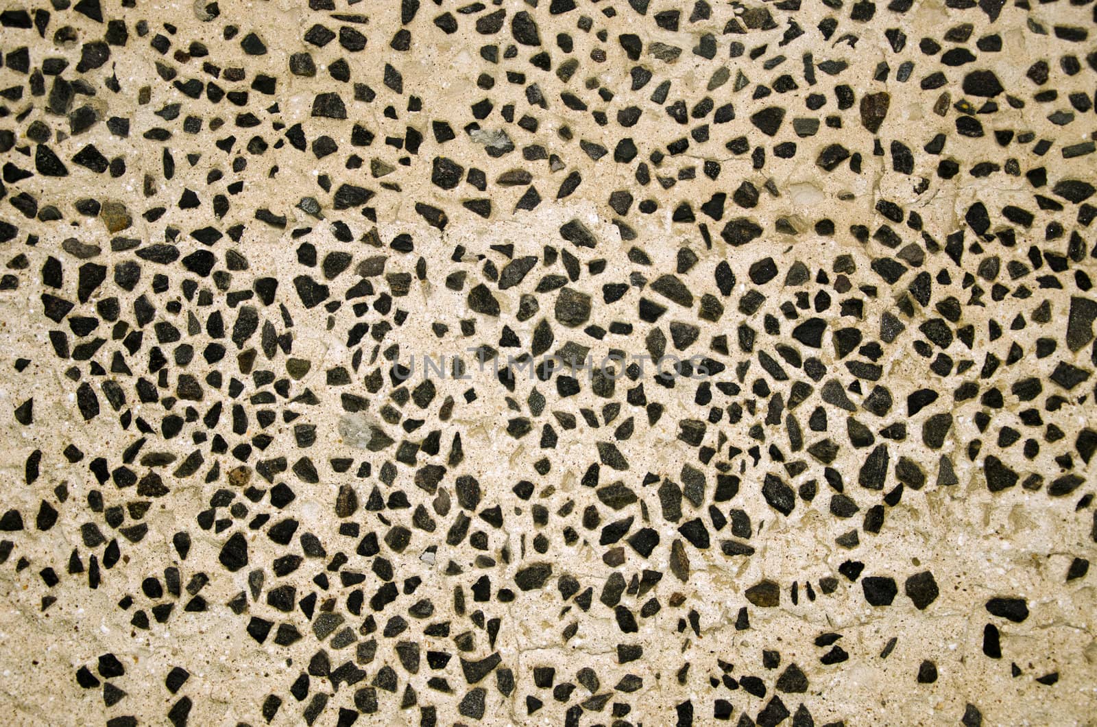 Wall decorated with small flint stones. Architecture background details.