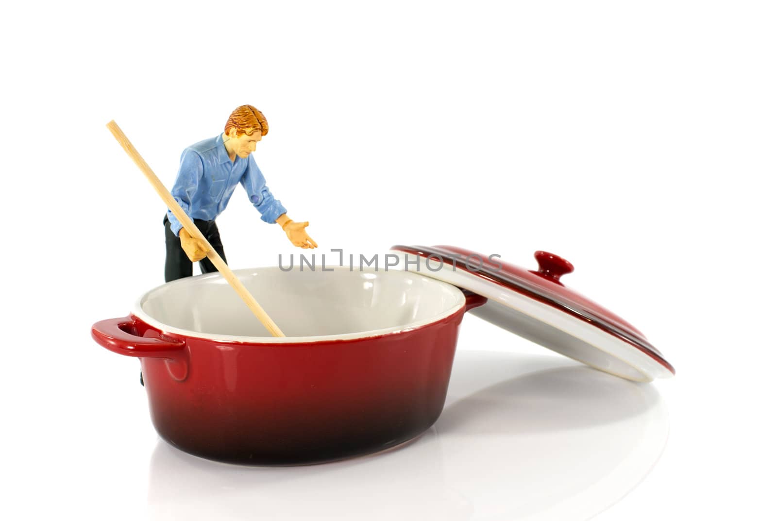 plastic puppet man stirring in red empty saucepan