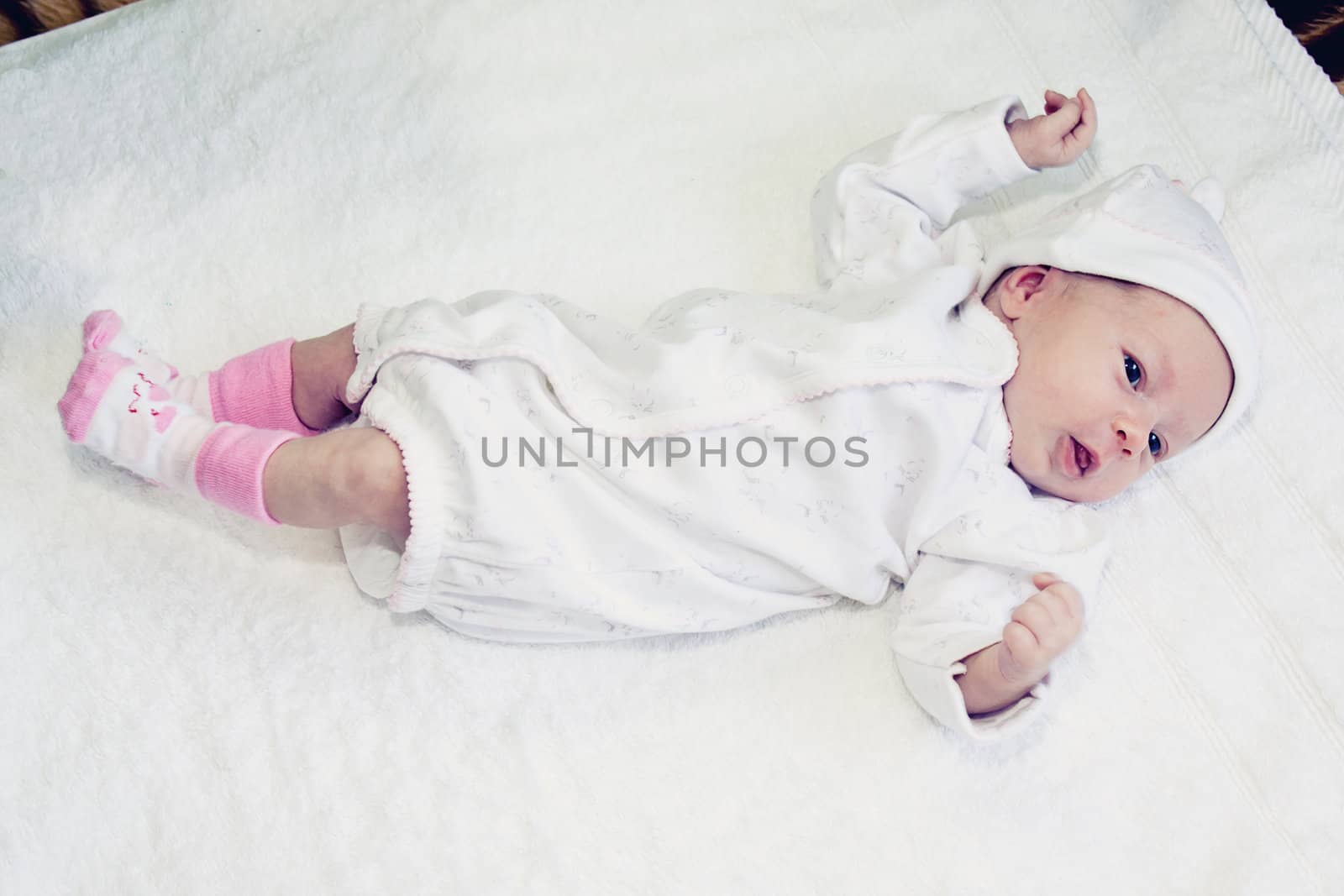 two weeks old baby girl on a white towel