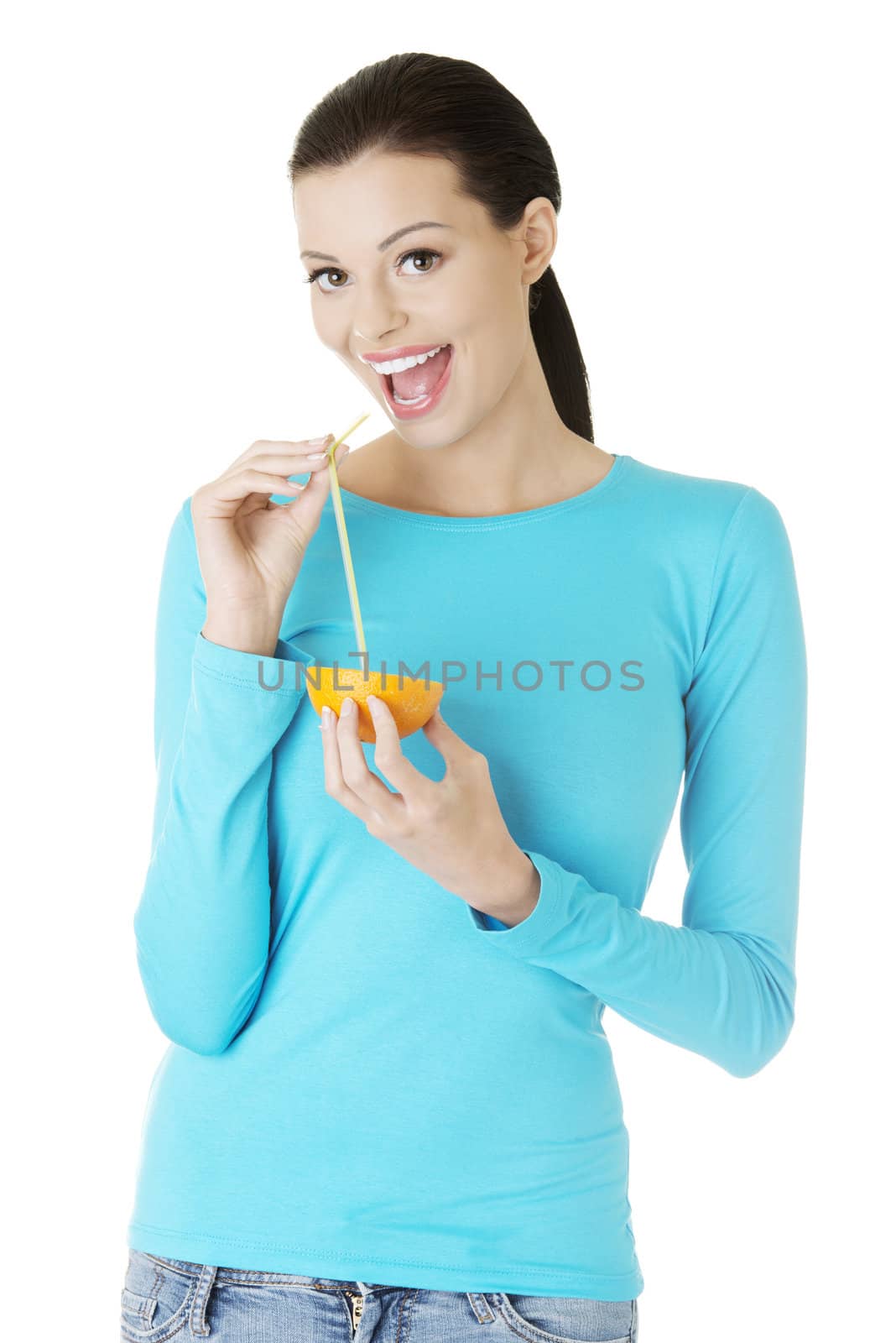 Woman drinking orange juice straight from fruit by BDS